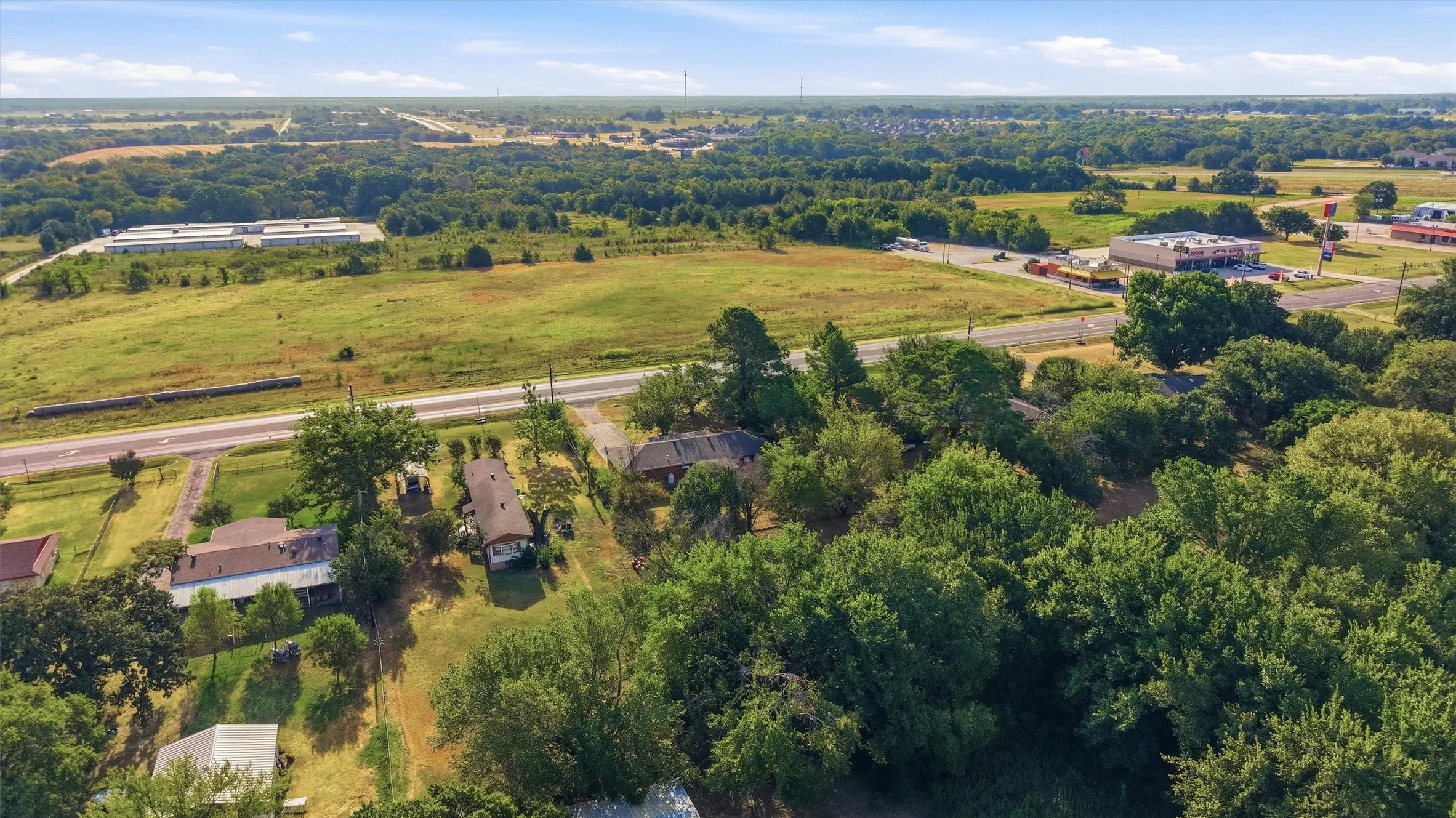 Extensive tree coverage surrounding the property, with a road passing through