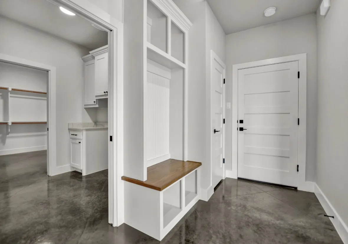 Mudroom entry featuring a built-in bench with wood-finish top and white cabinetry