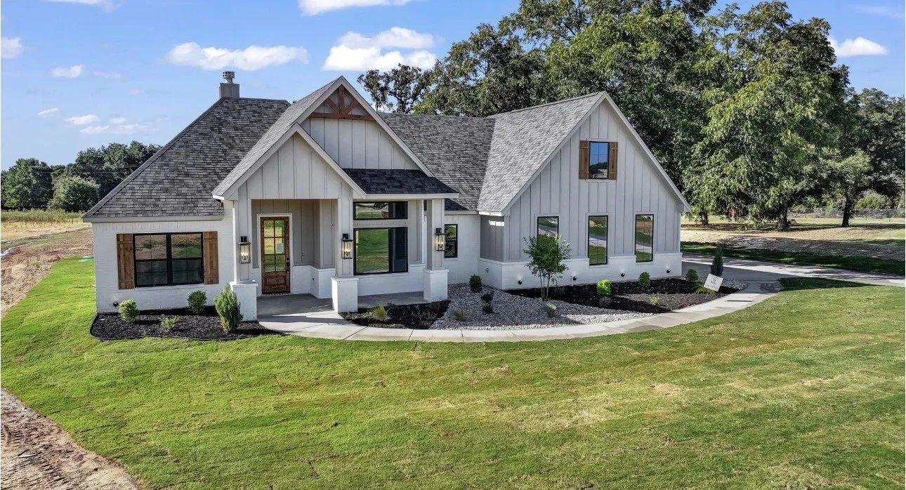 Modern farmhouse exterior with board and batten siding, dark shingle roof, and an inviting covered porch