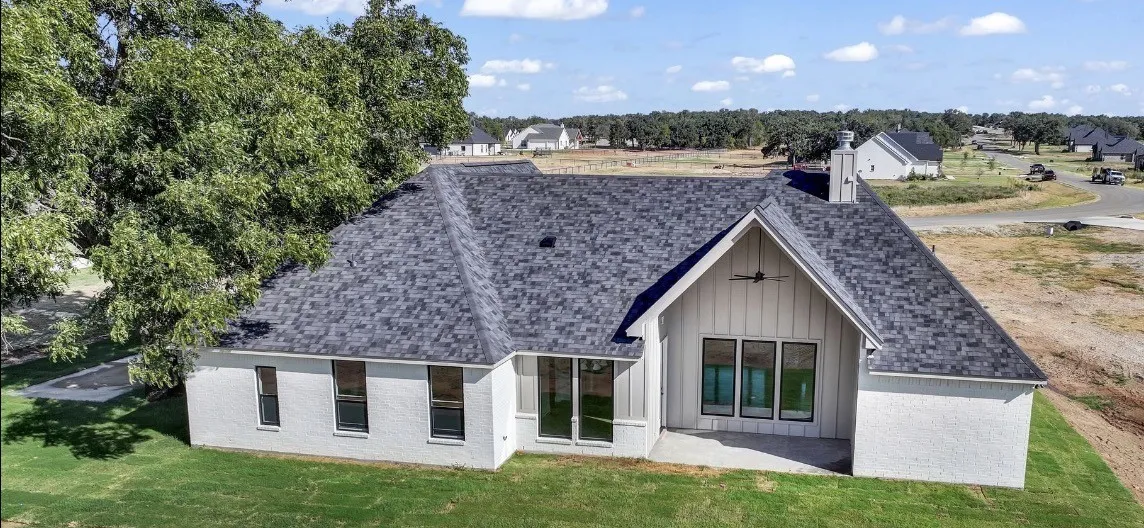 White stucco exterior with a gray shingle roof
