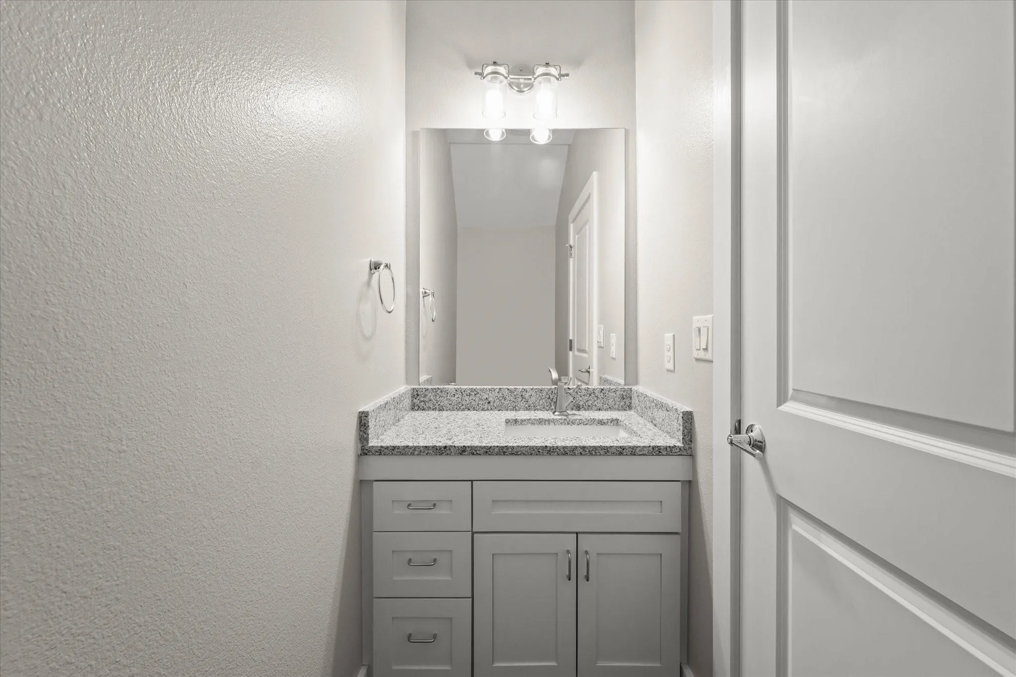 Single vanity with a light-toned countertop, undermount sink, and chrome faucet
