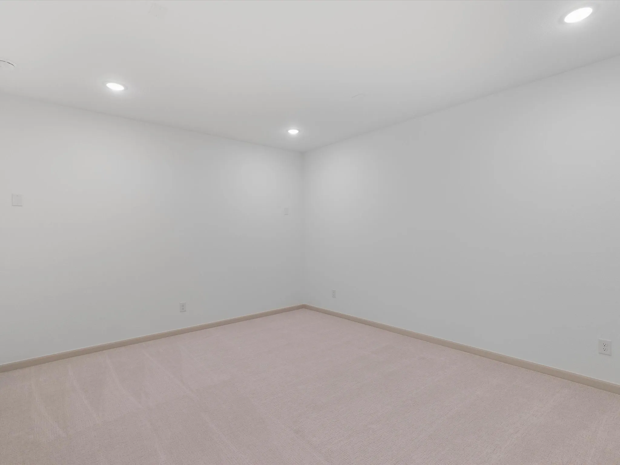 Recessed lighting illuminates the carpeted flooring and light-toned walls