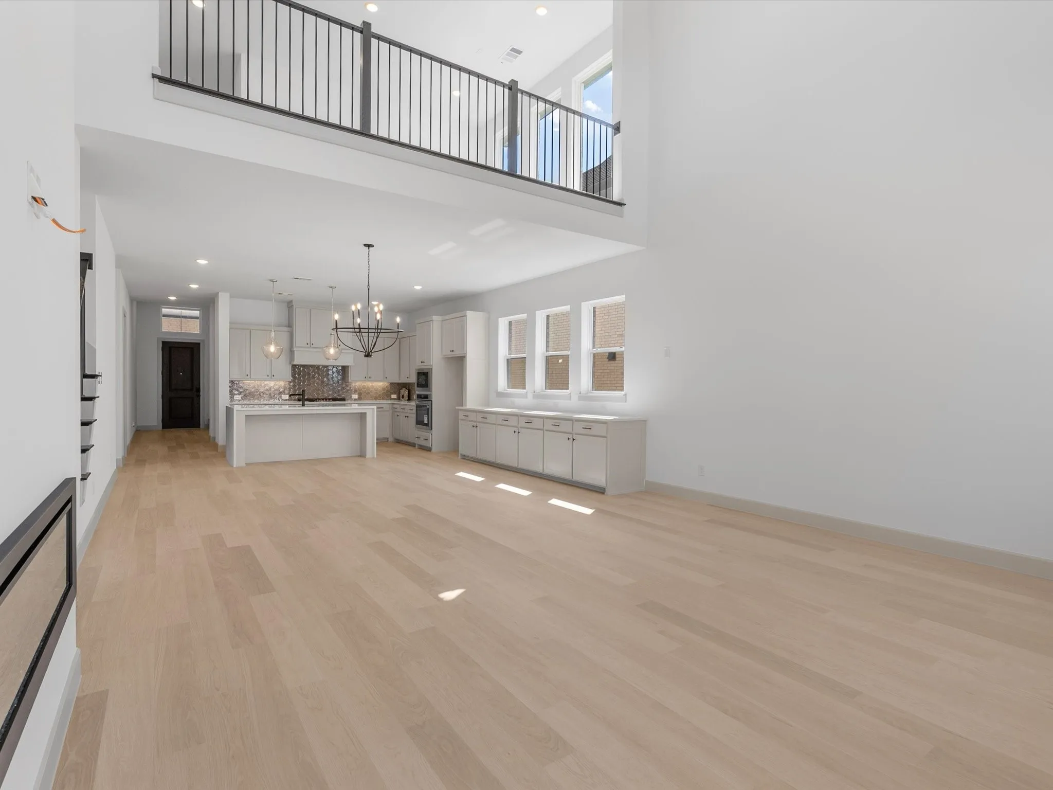 Expansive open-concept living area with light wood-finish flooring