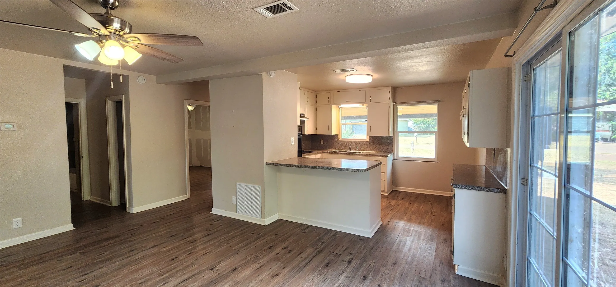Vinyl flooring throughout, with a ceiling fan in the living area