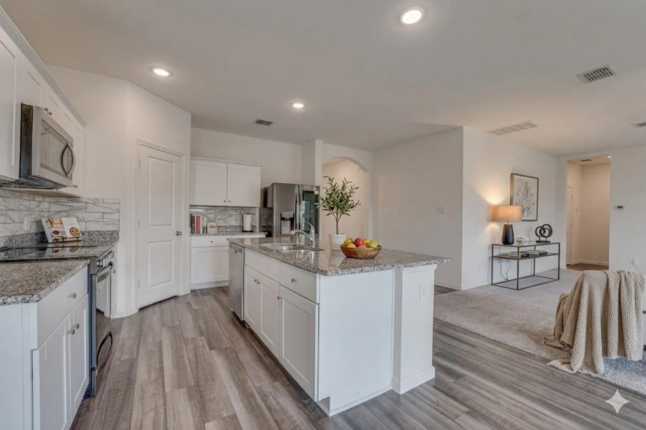 Modern kitchen featuring a central island, white cabinetry, granite countertops, and stainless steel appliances
