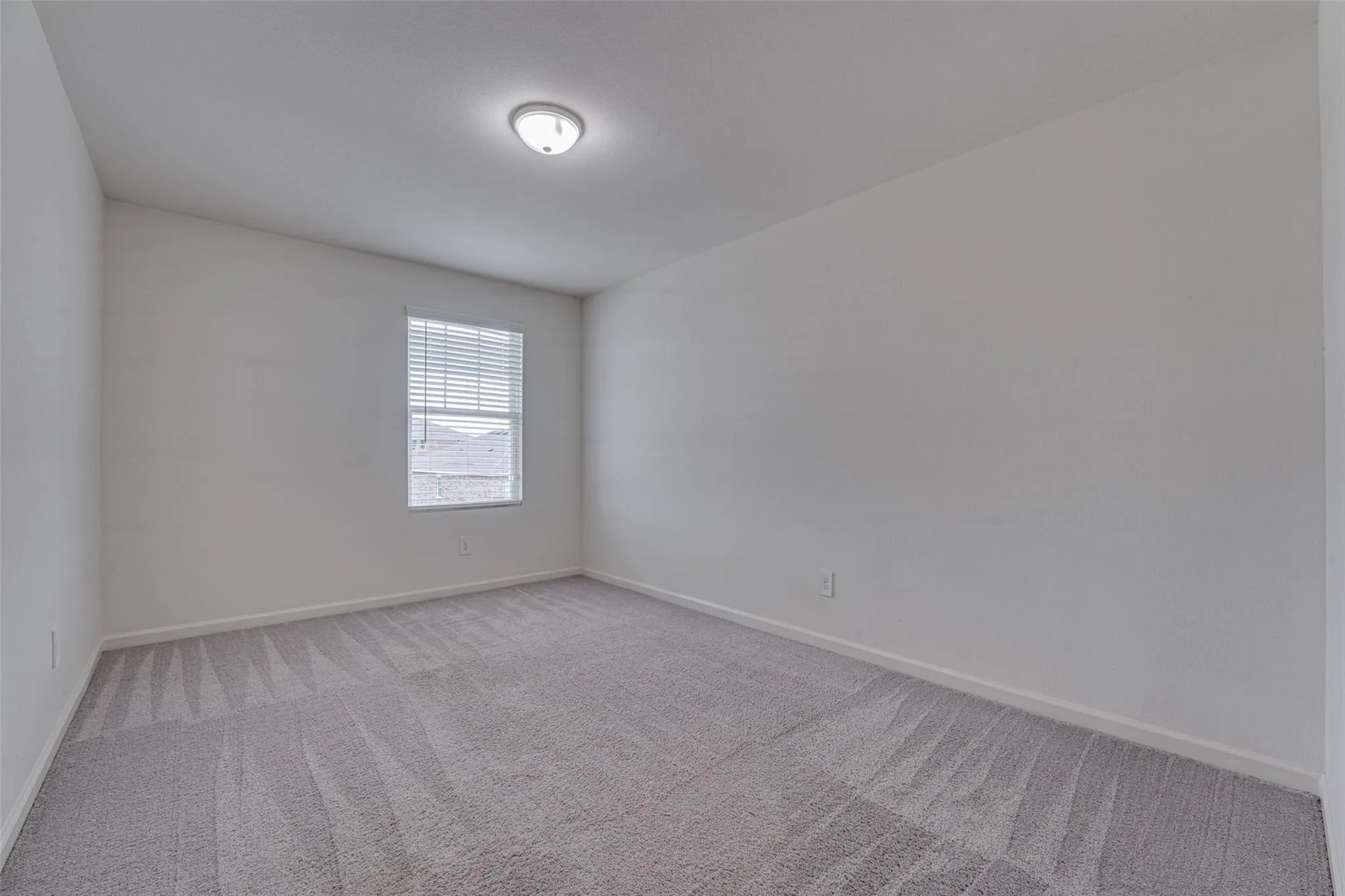 Neutral wall tones, carpeted flooring, window with blinds, and ceiling-mounted light fixture