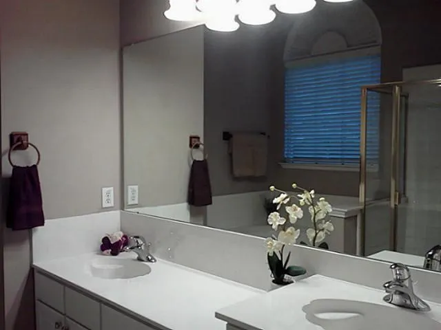 Dual vanity with integrated sinks, expansive mirror, and chrome fixtures