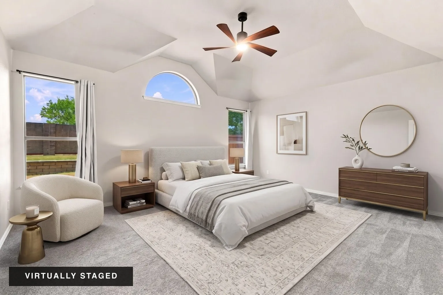 Vaulted ceiling, ceiling fan, large windows, arched window, and gray carpet flooring