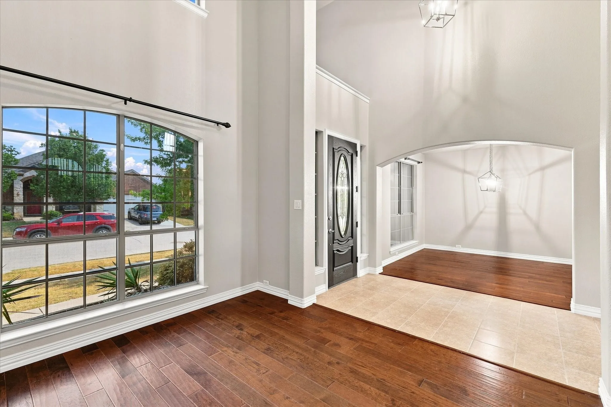 Two-story entry foyer with tile flooring and a decorative front door