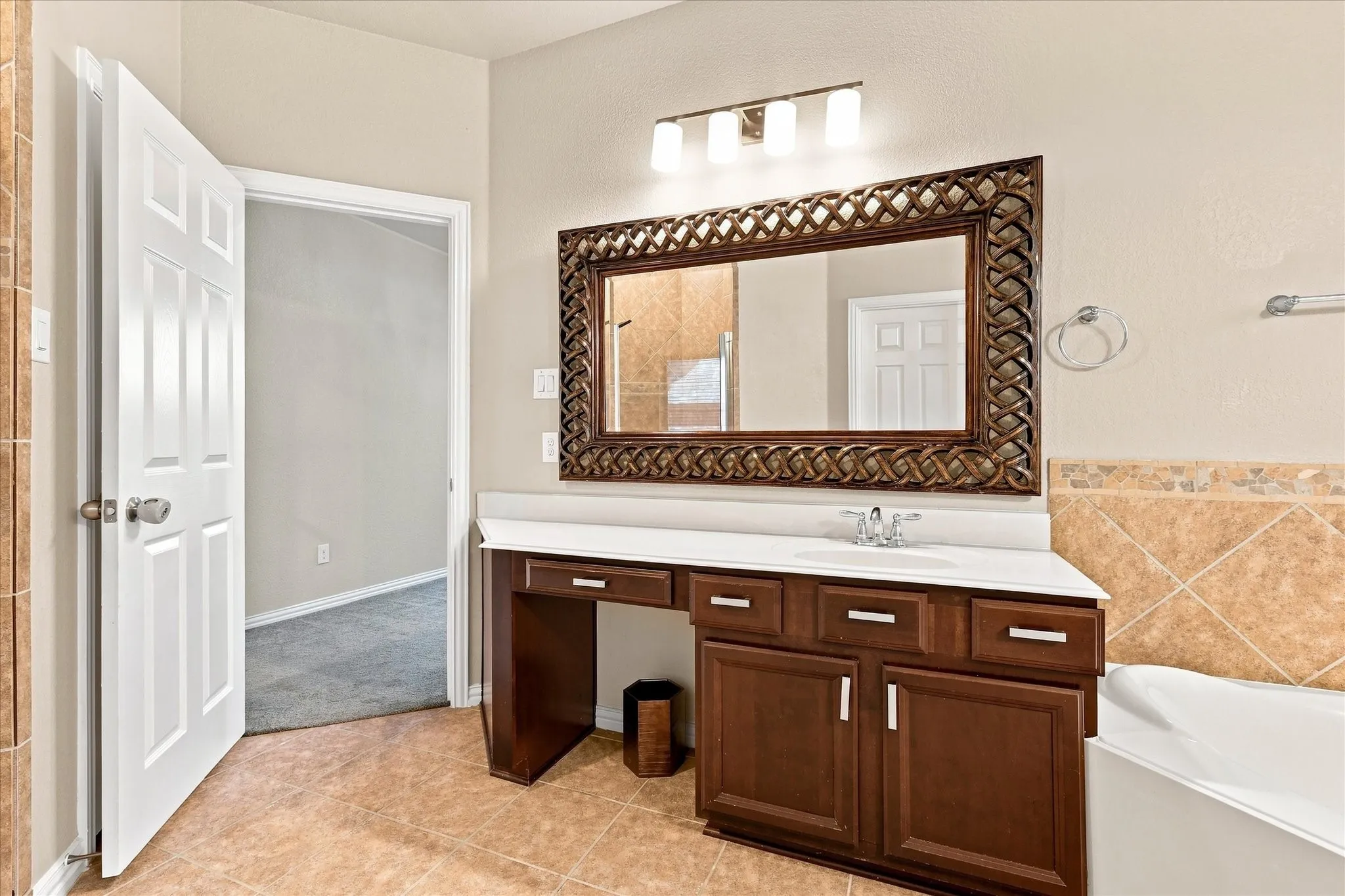 Vanity with a white countertop, integrated sink, and dark wood cabinetry featuring brushed nickel hardware