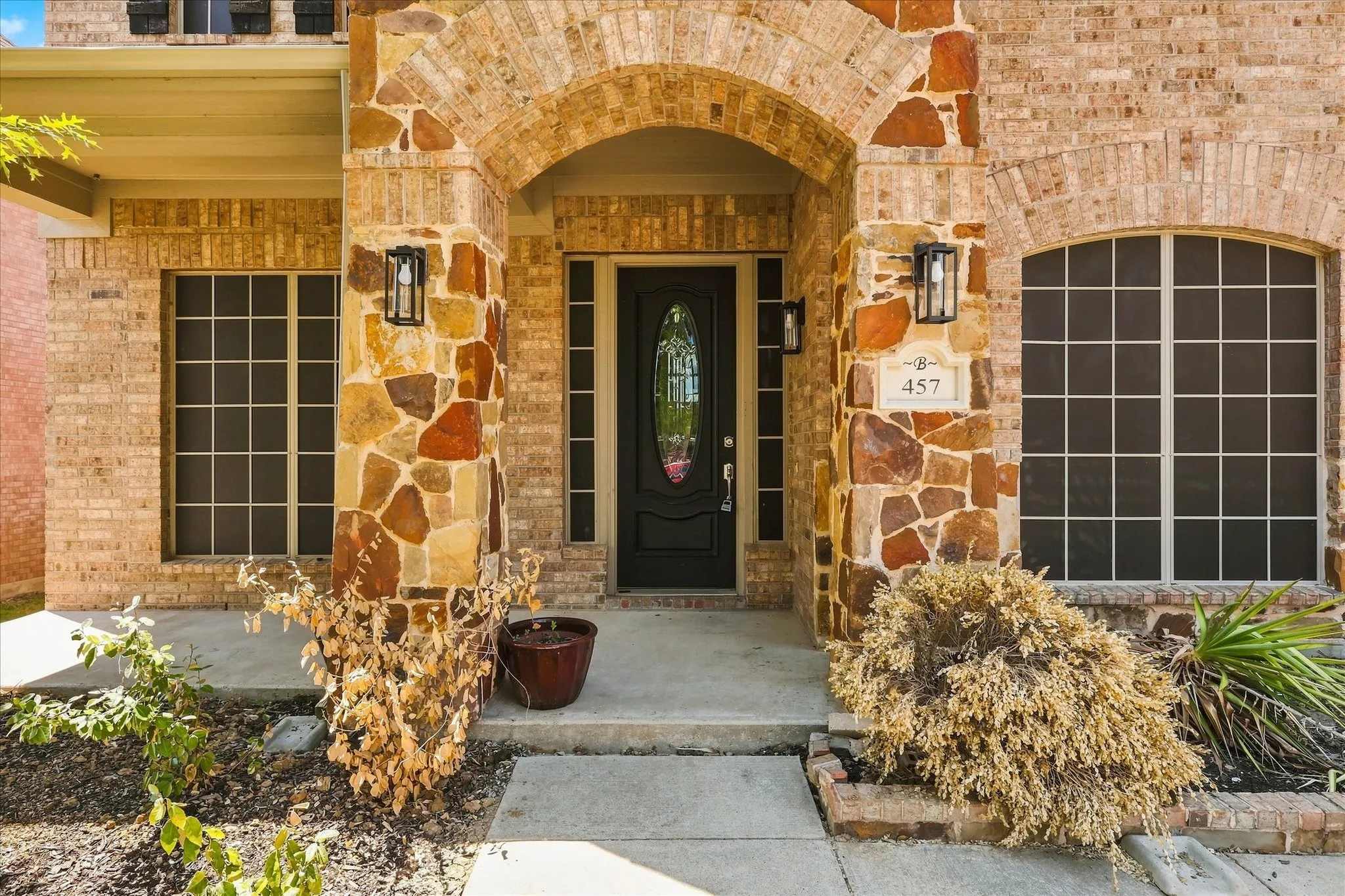 Brick and stone facade featuring an arched entryway