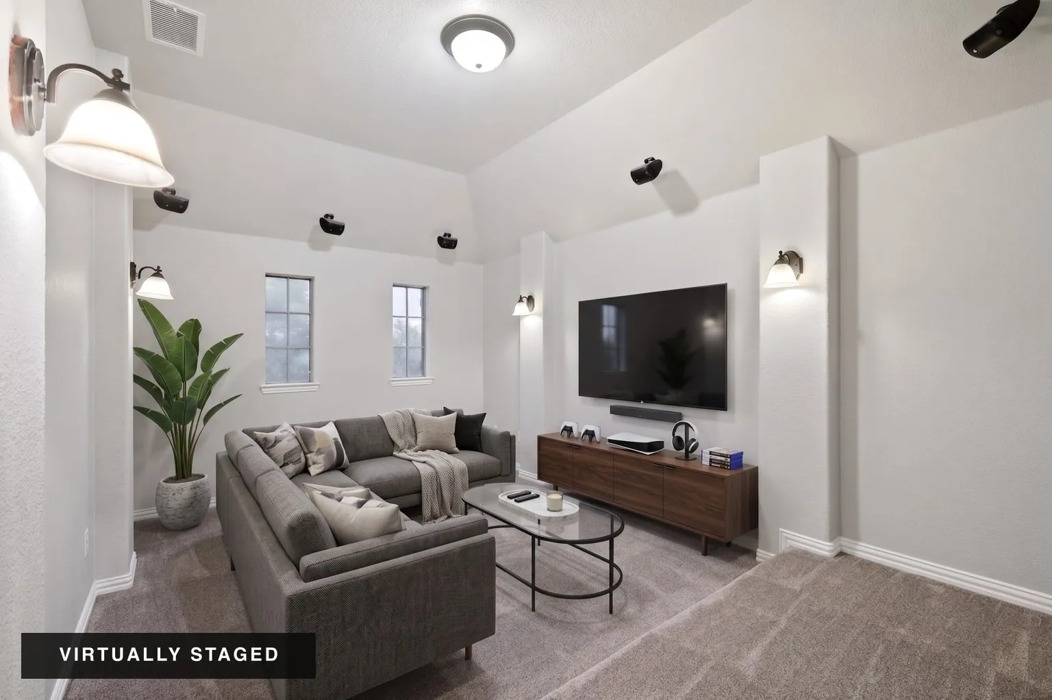 Carpeted room with vaulted ceiling, multiple recessed windows, and wall sconce lighting fixtures