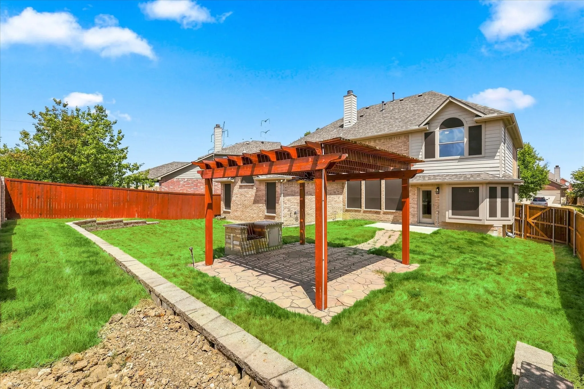 Expansive backyard featuring a wood pergola over a paver patio, a built-in outdoor cooking station, and privacy​​‌​​​​‌​​‌‌​‌‌​​​‌‌​‌​‌​‌​​​‌​​ fencing