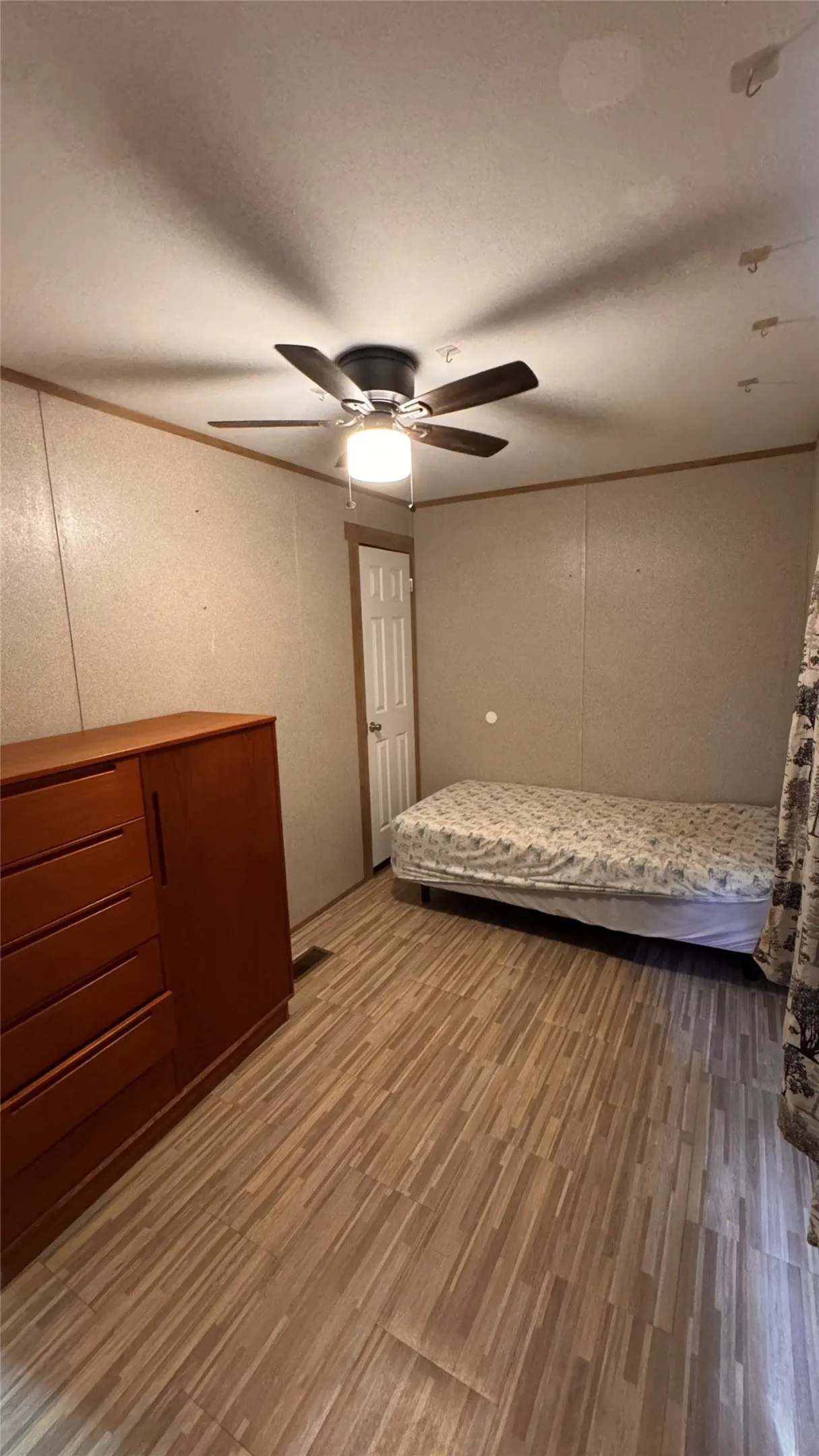 Wood-finish flooring with a ceiling fan light fixture
