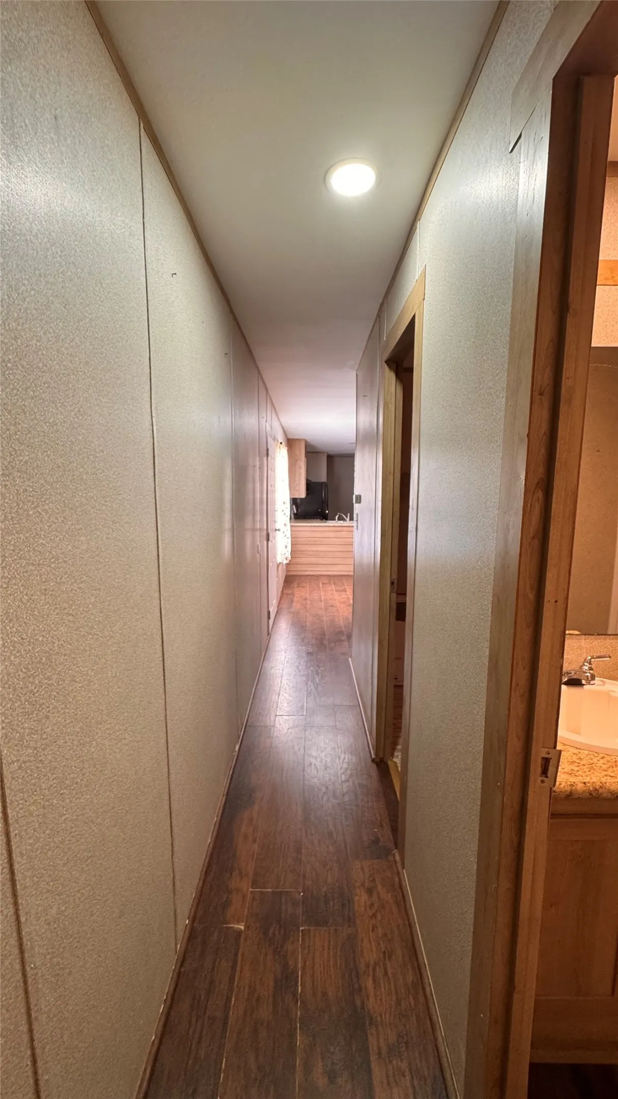 Recessed lighting illuminates the wood-finish flooring