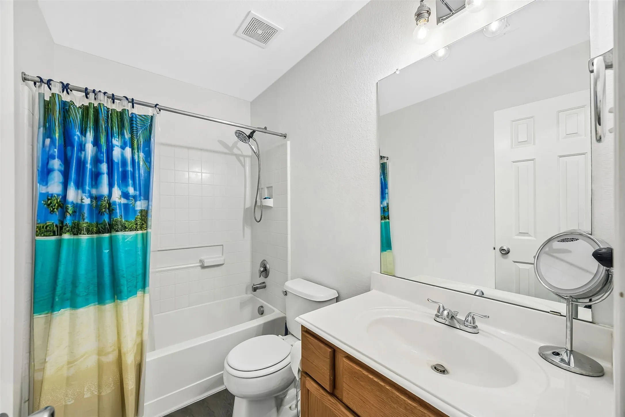 Bathroom featuring a full vanity with a white countertop, undermount sink, and wood-finish cabinetry