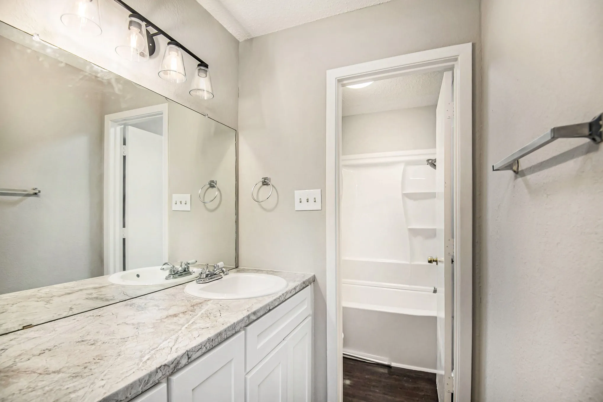 Dual vanity with white cabinetry and a patterned countertop