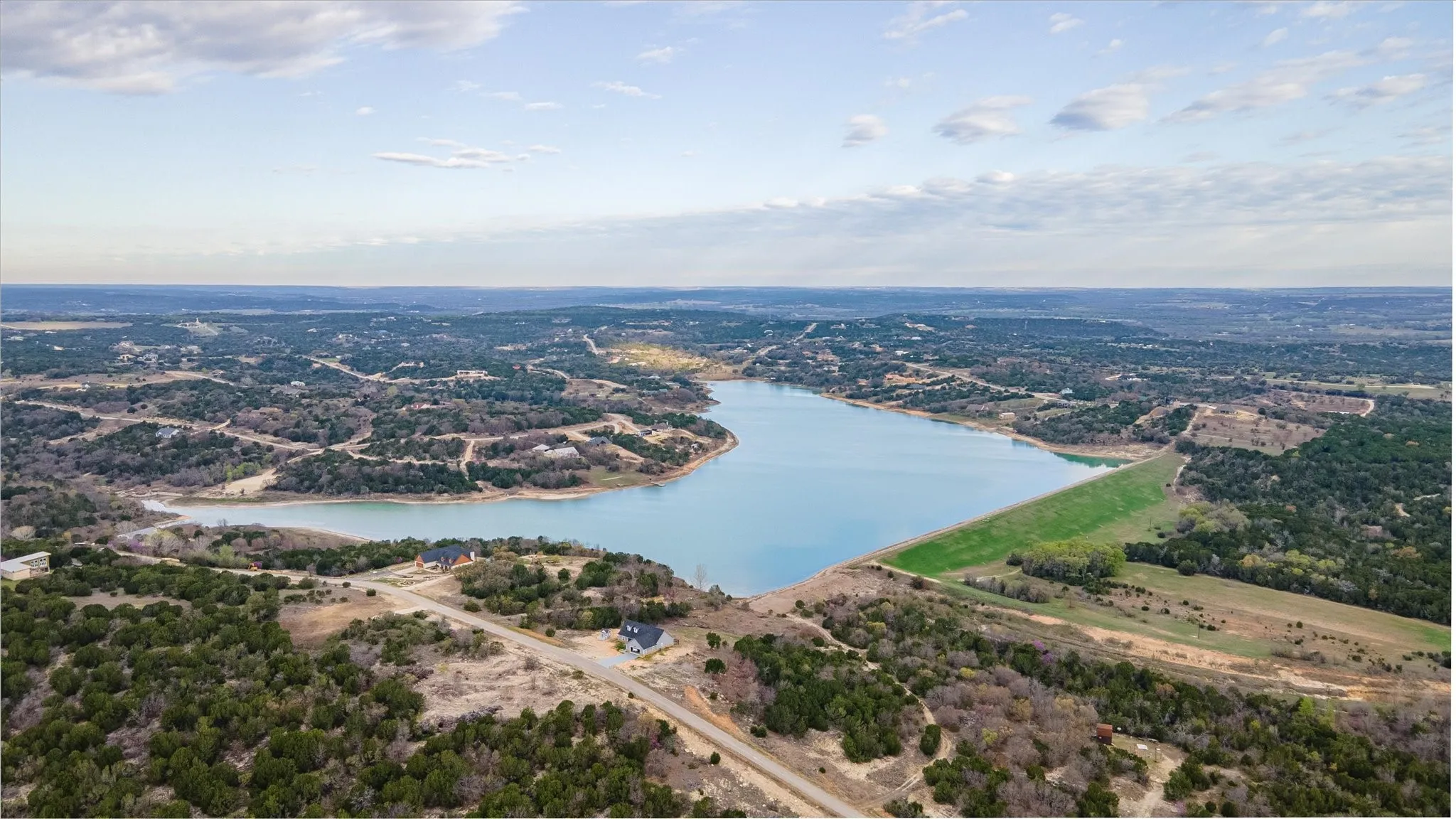 Expansive water body surrounded by natural landscapes and residential properties