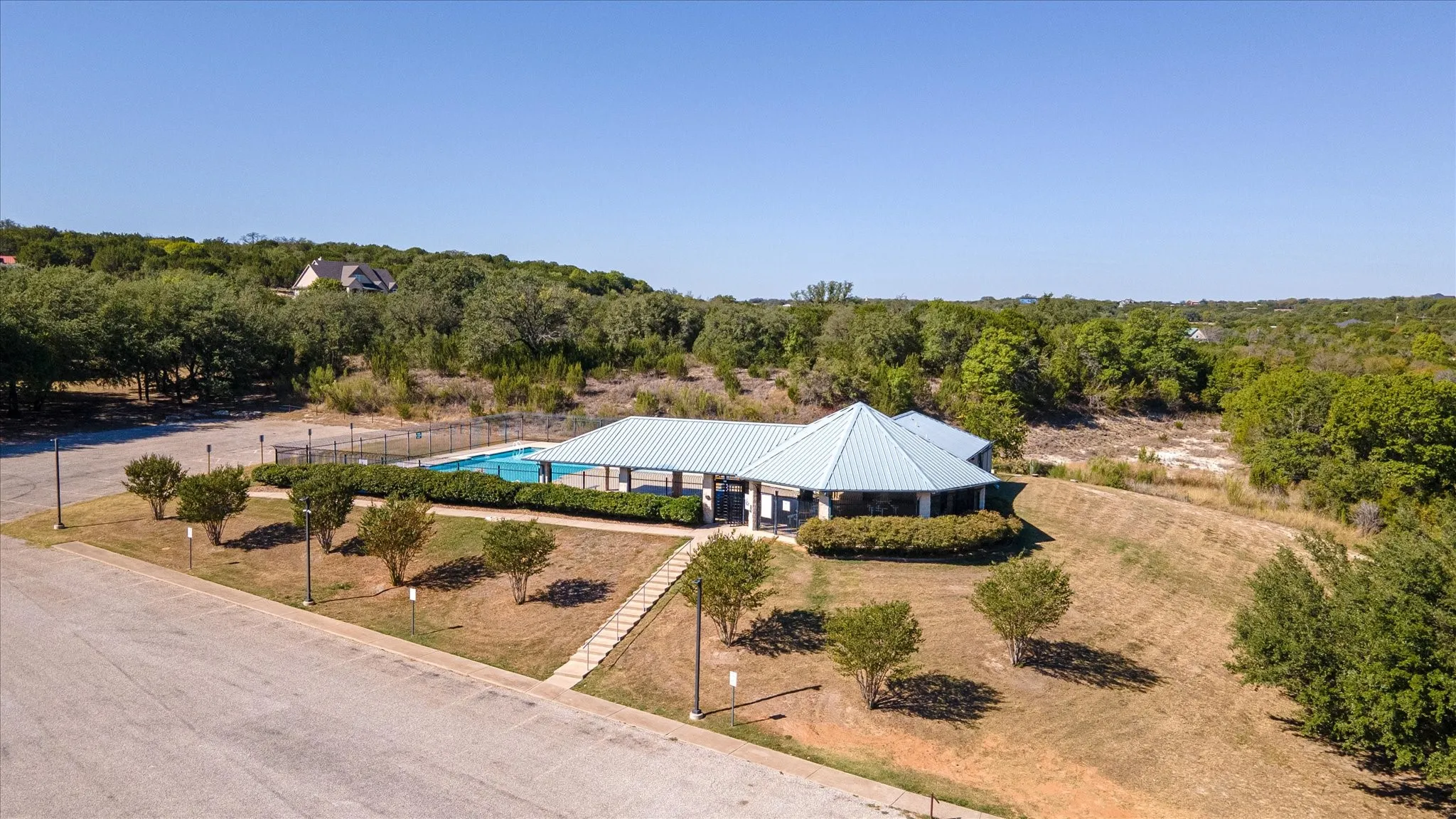 Community swimming pool with a covered pavilion and surrounding green space