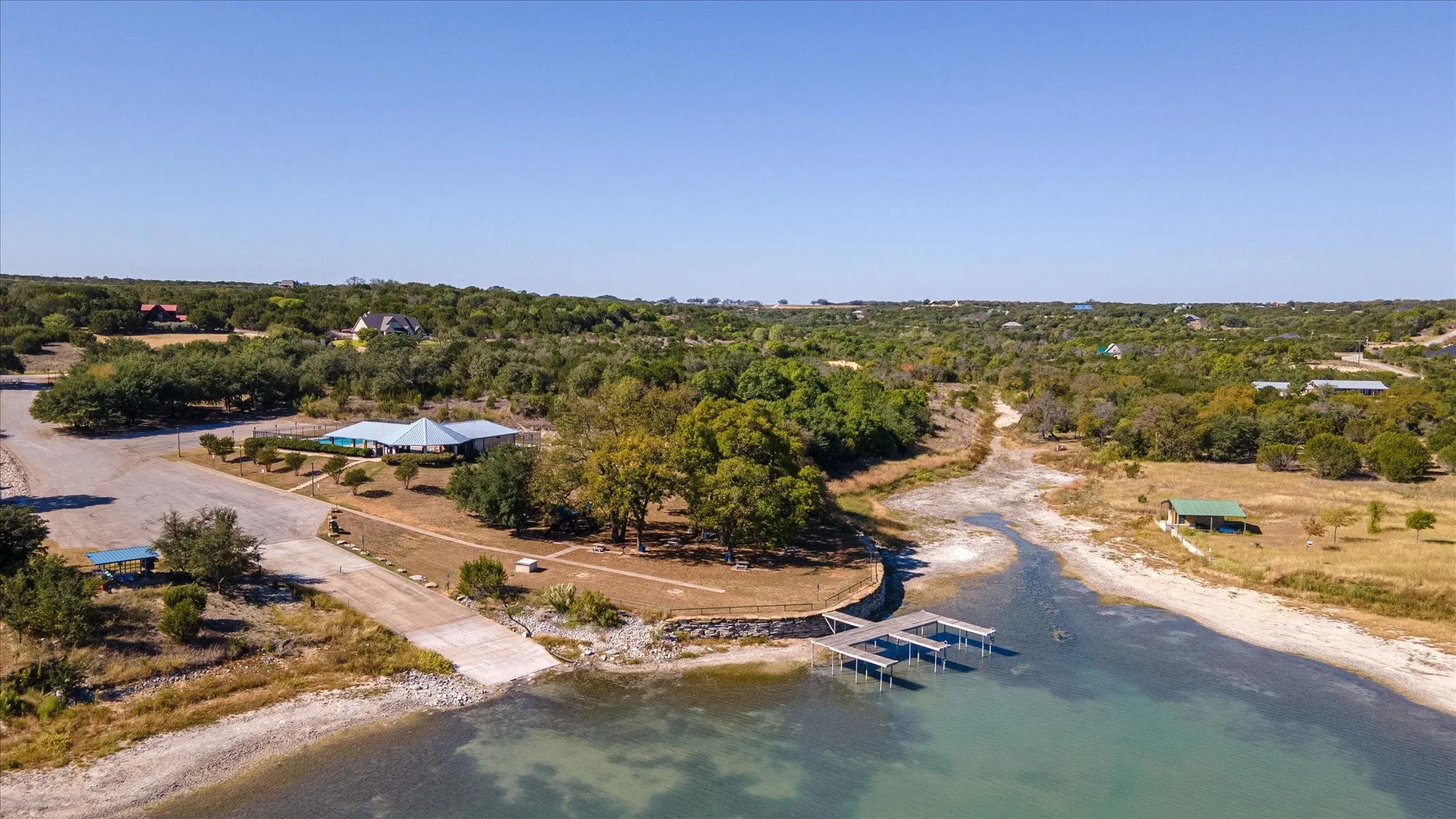 Waterfront property featuring a boat ramp, multiple docks, and abundant mature trees
