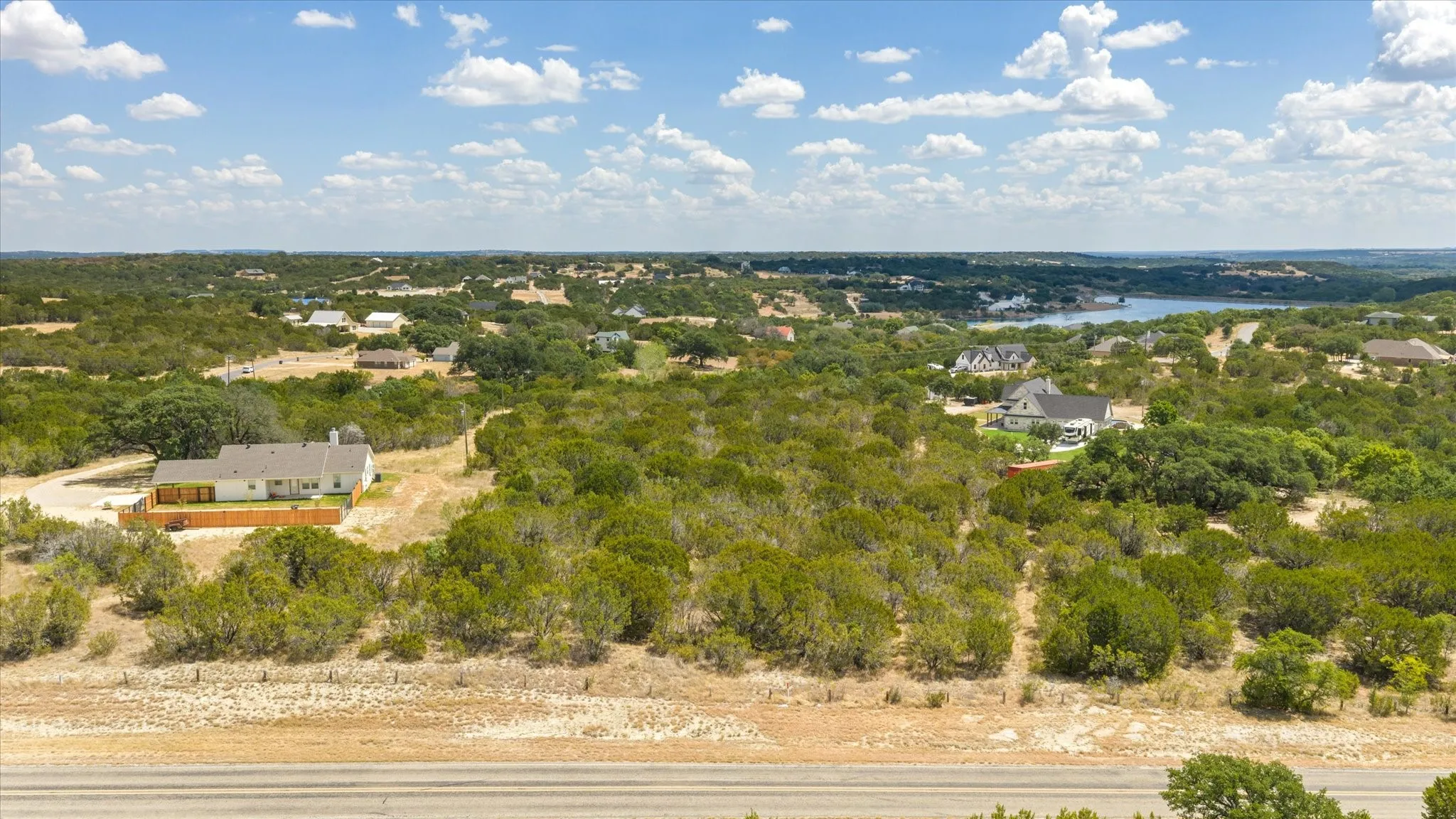 Expansive land parcel featuring dense natural foliage and distant water
