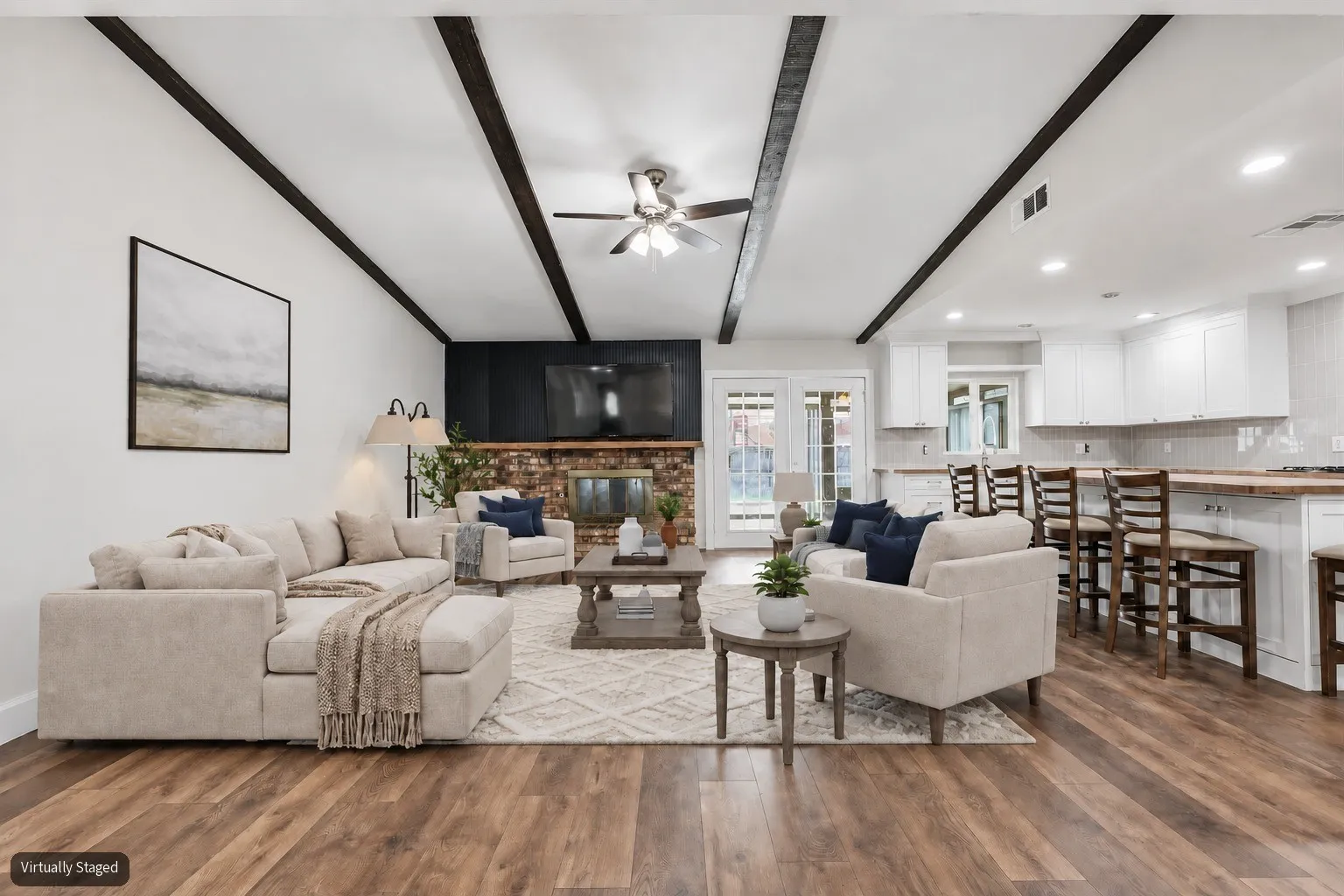 Virtually staged living room open to beautiful kitchen with large island with seating.