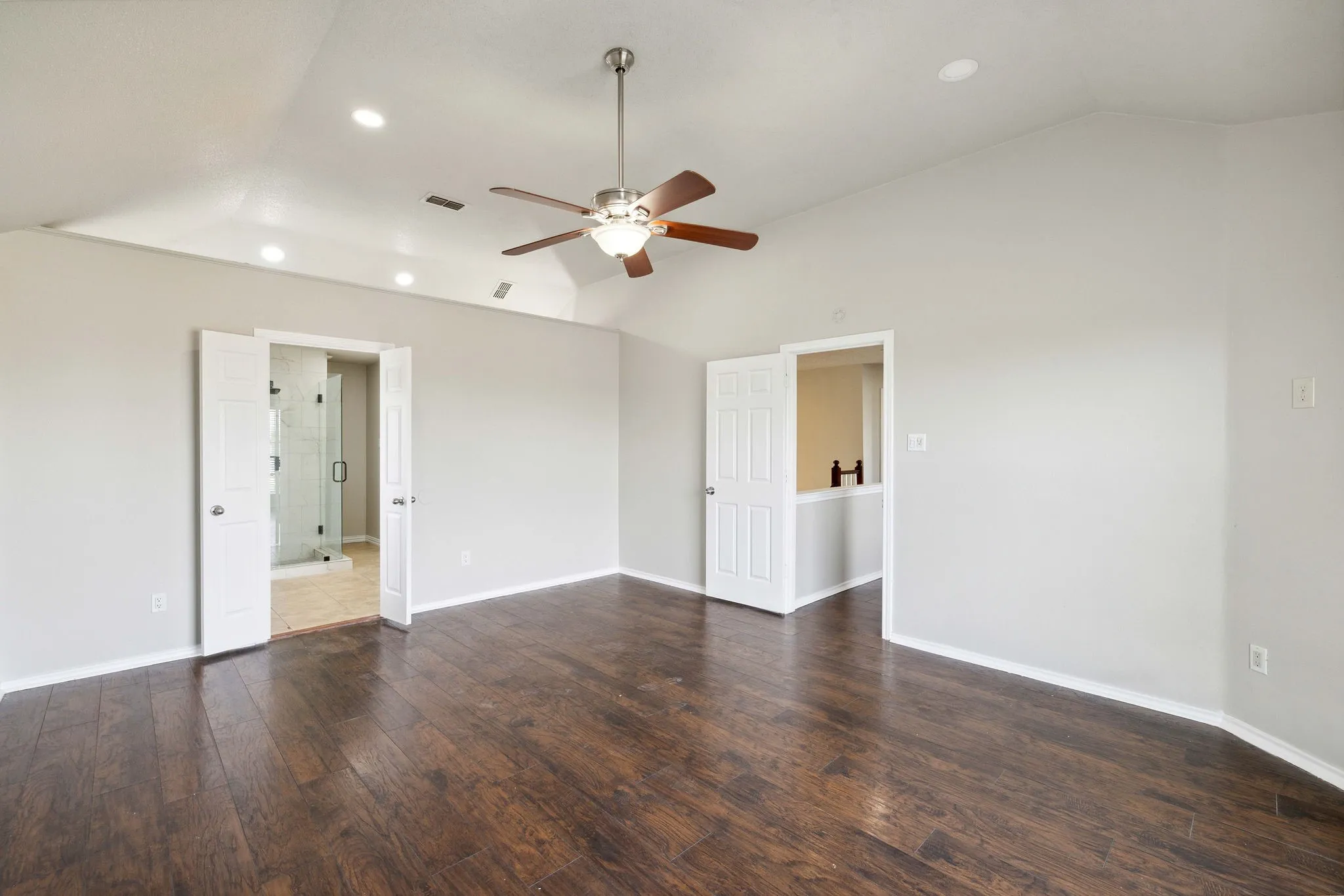 Unfurnished room with dark hardwood / wood-style floors, ceiling fan, and vaulted ceiling