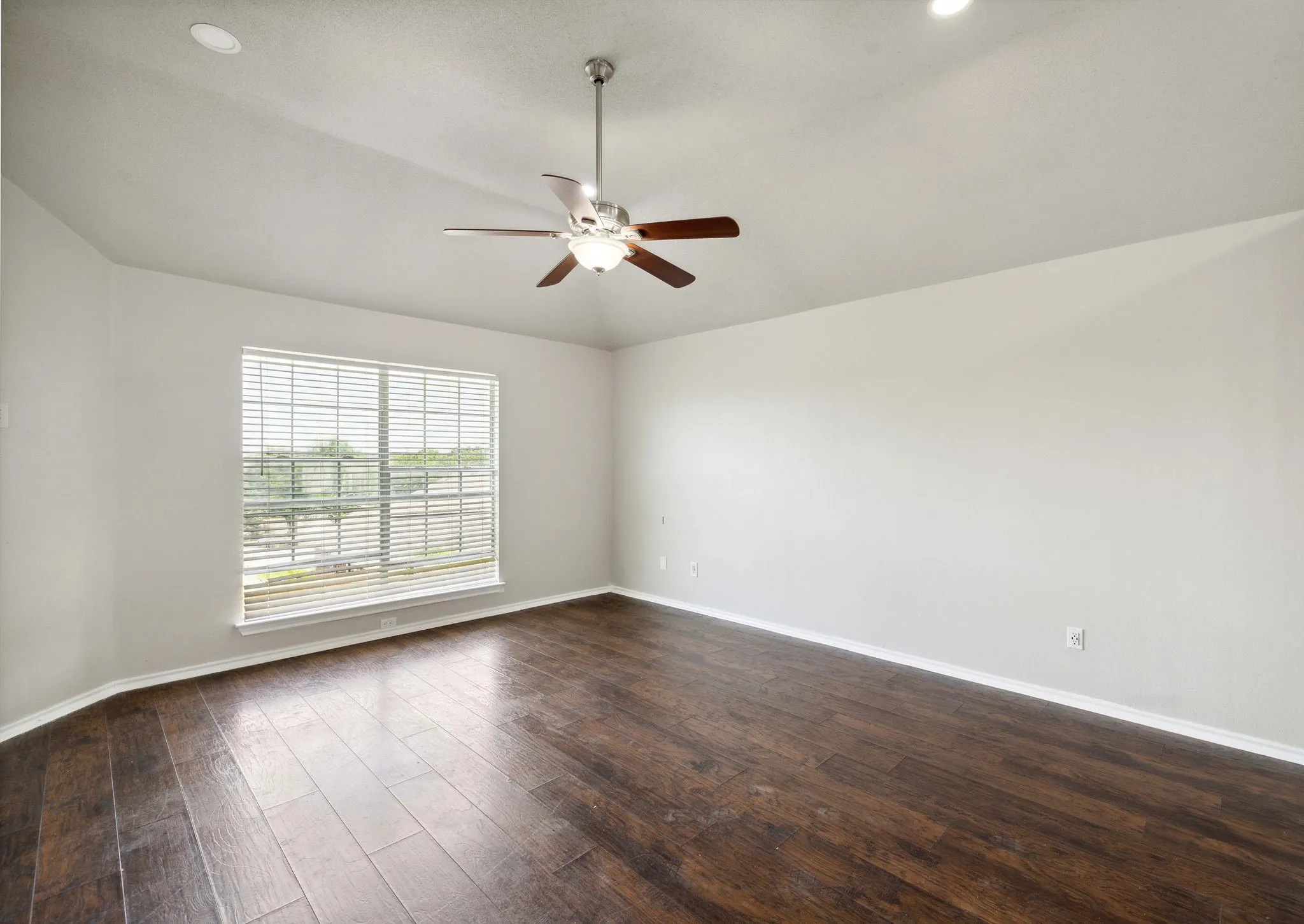 Unfurnished room featuring dark hardwood / wood-style floors, ceiling fan, and vaulted ceiling