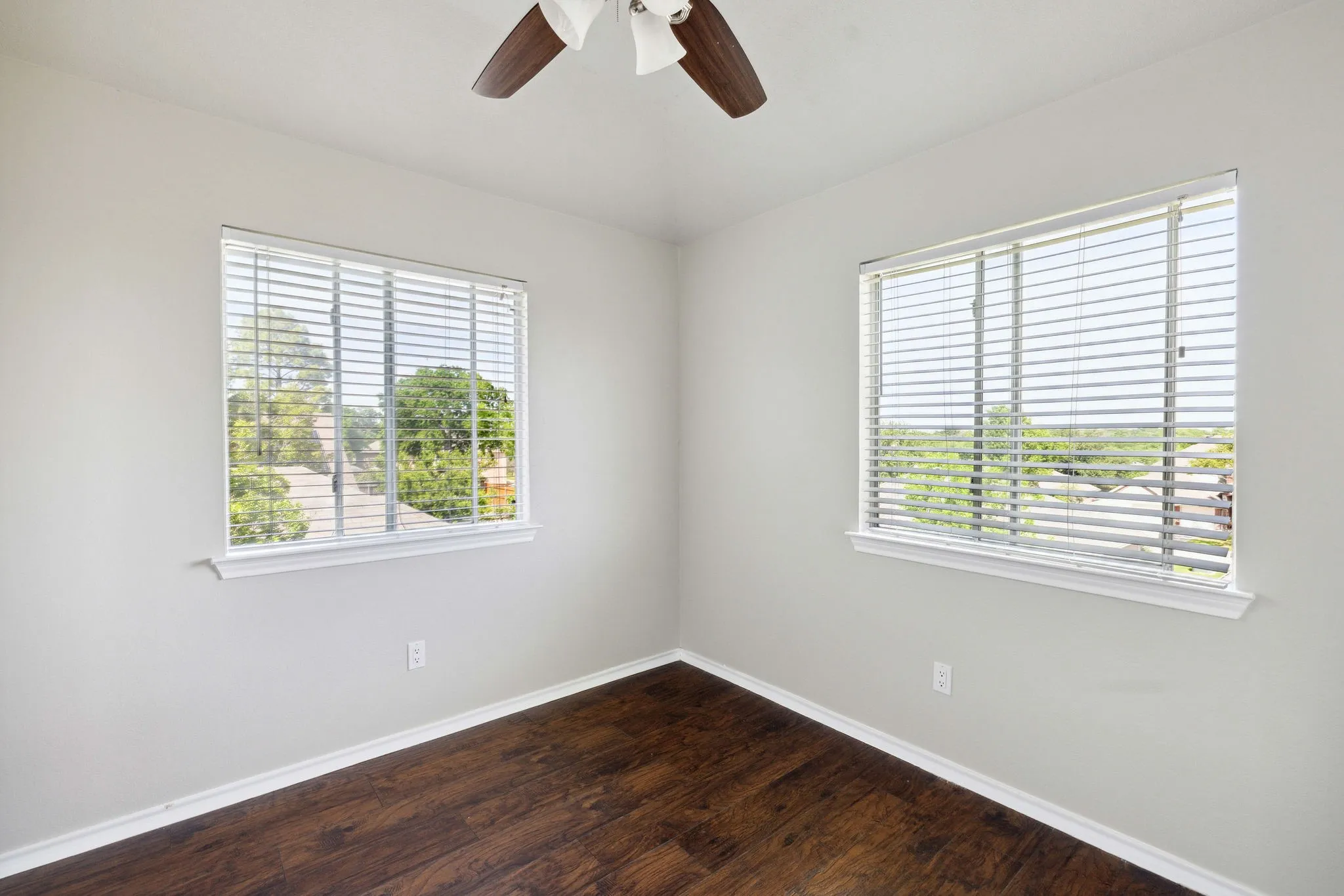 Empty room featuring a wealth of natural light and dark hardwood / wood-style flooring