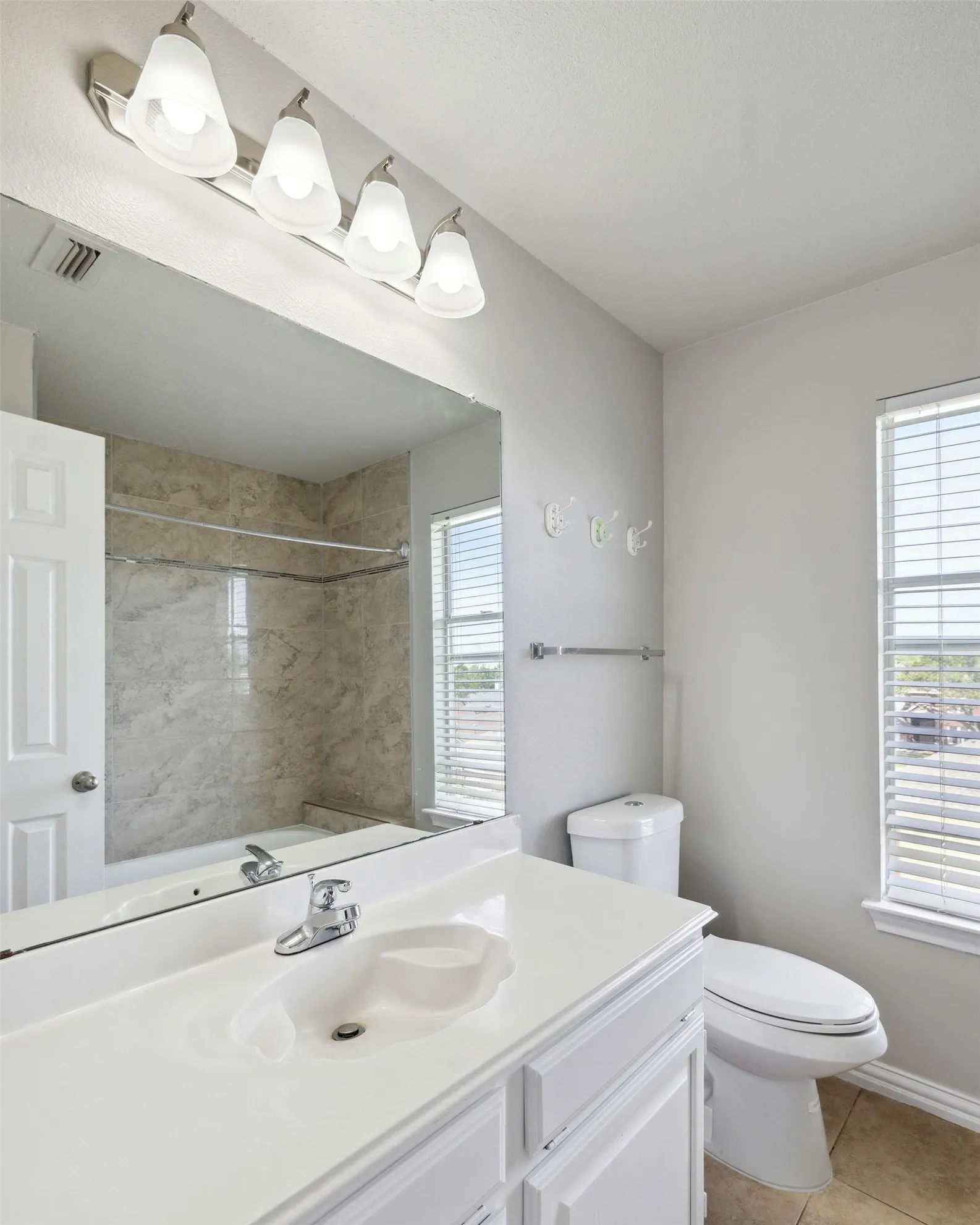 Bathroom with toilet, tile flooring, and large vanity