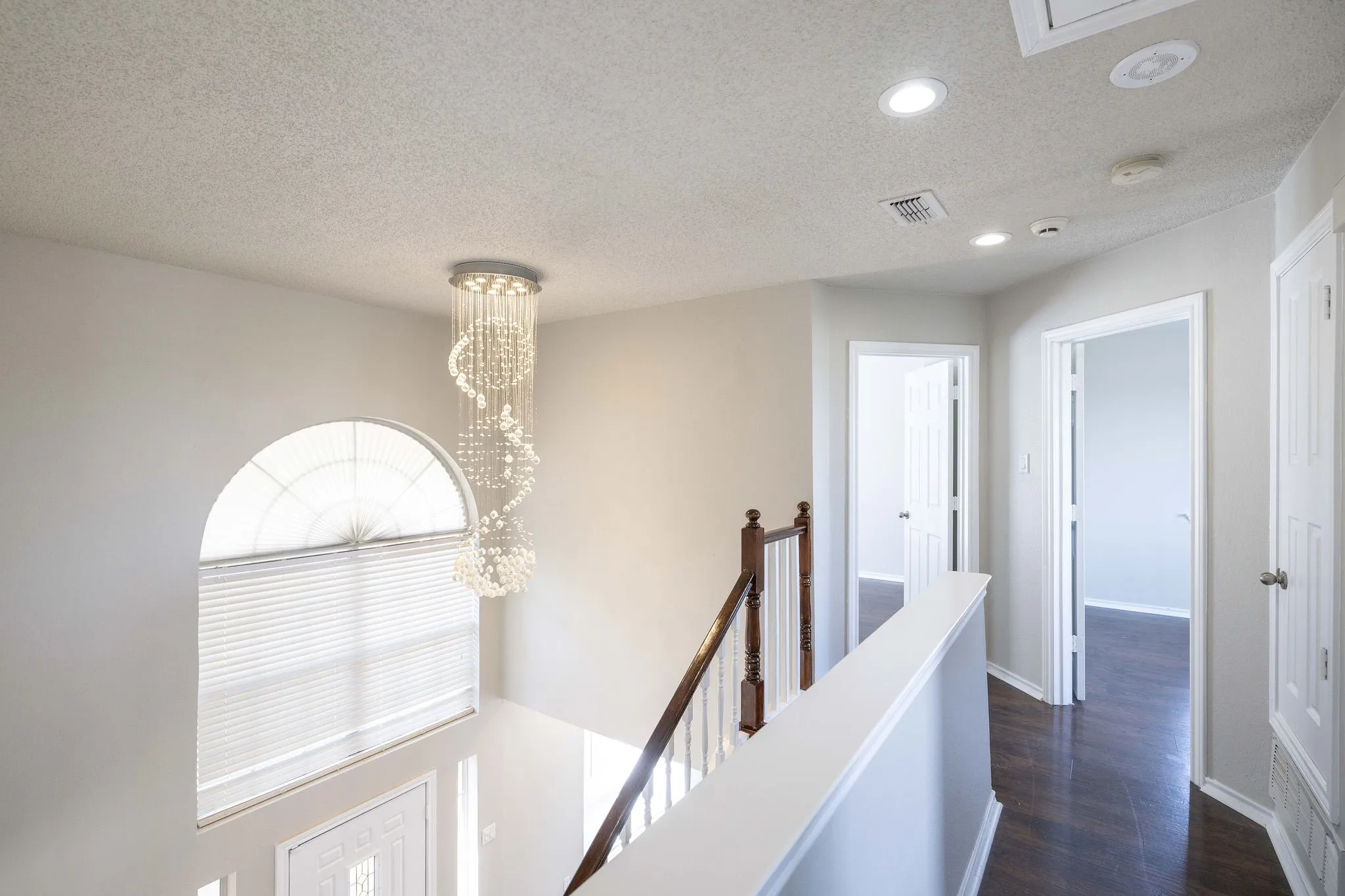 Hall featuring an inviting chandelier, dark hardwood / wood-style floors, and a textured ceiling