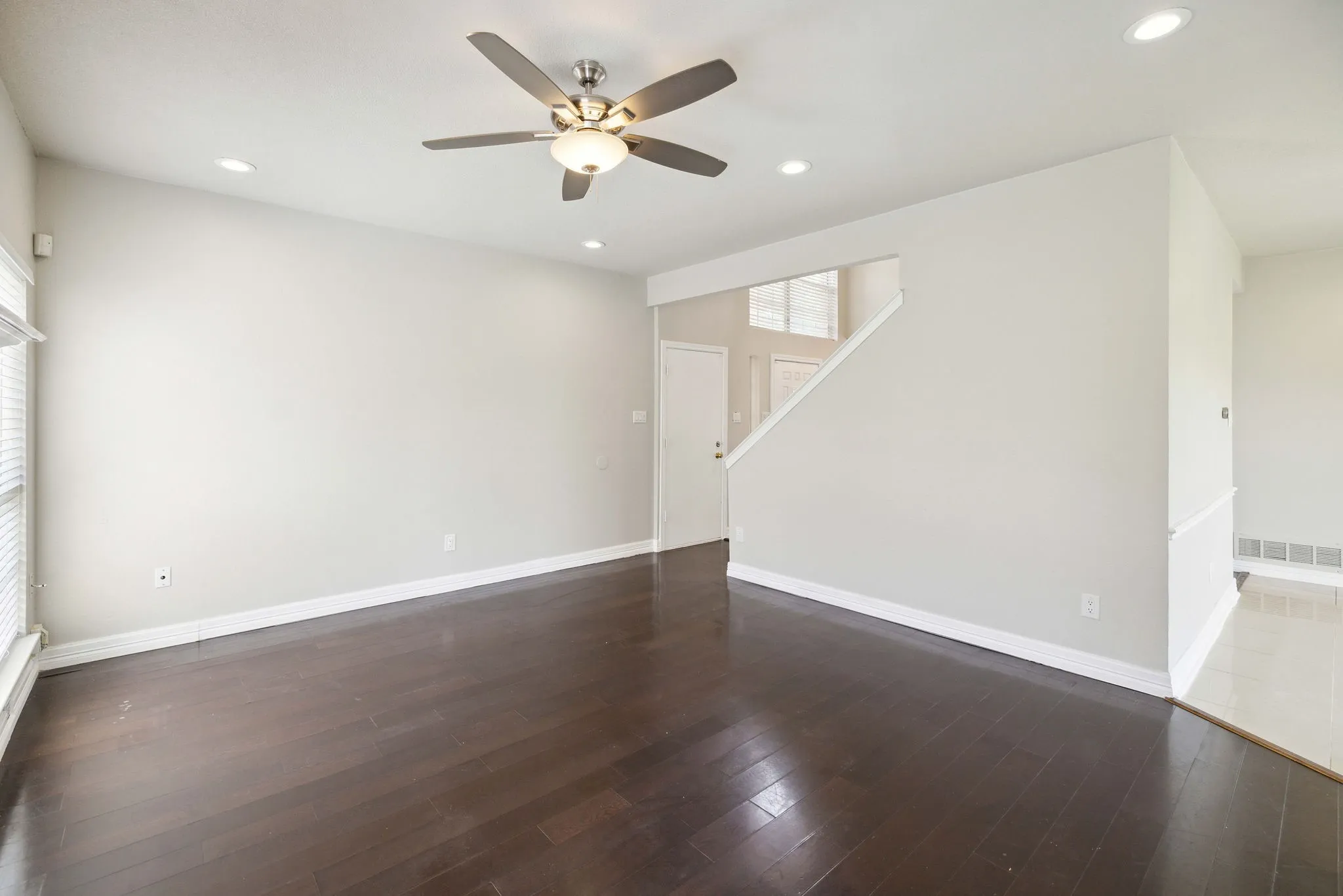 Spare room with dark hardwood / wood-style flooring and ceiling fan