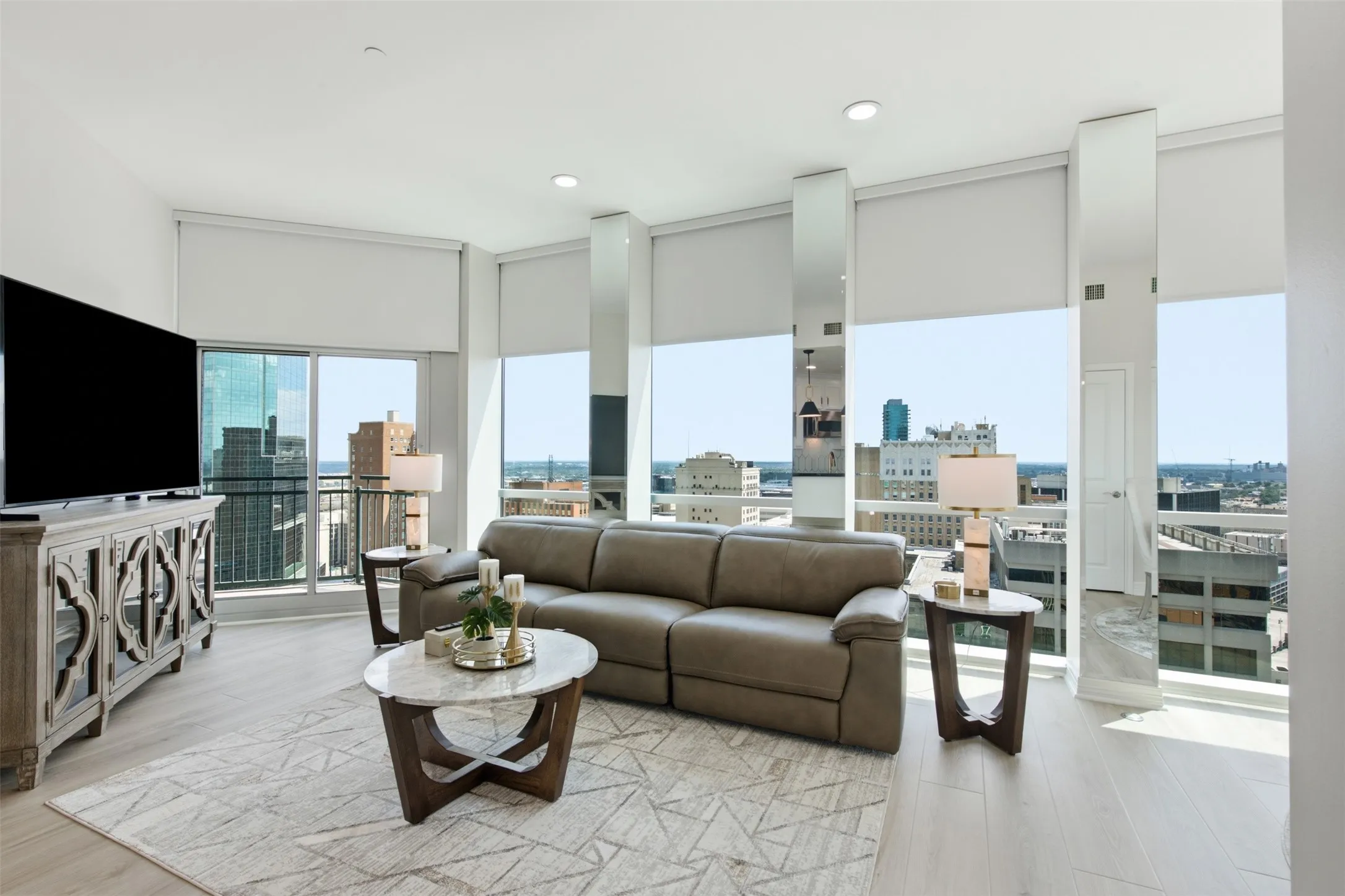 Spacious living area featuring light wood-finish flooring, recessed lighting, and expansive windows