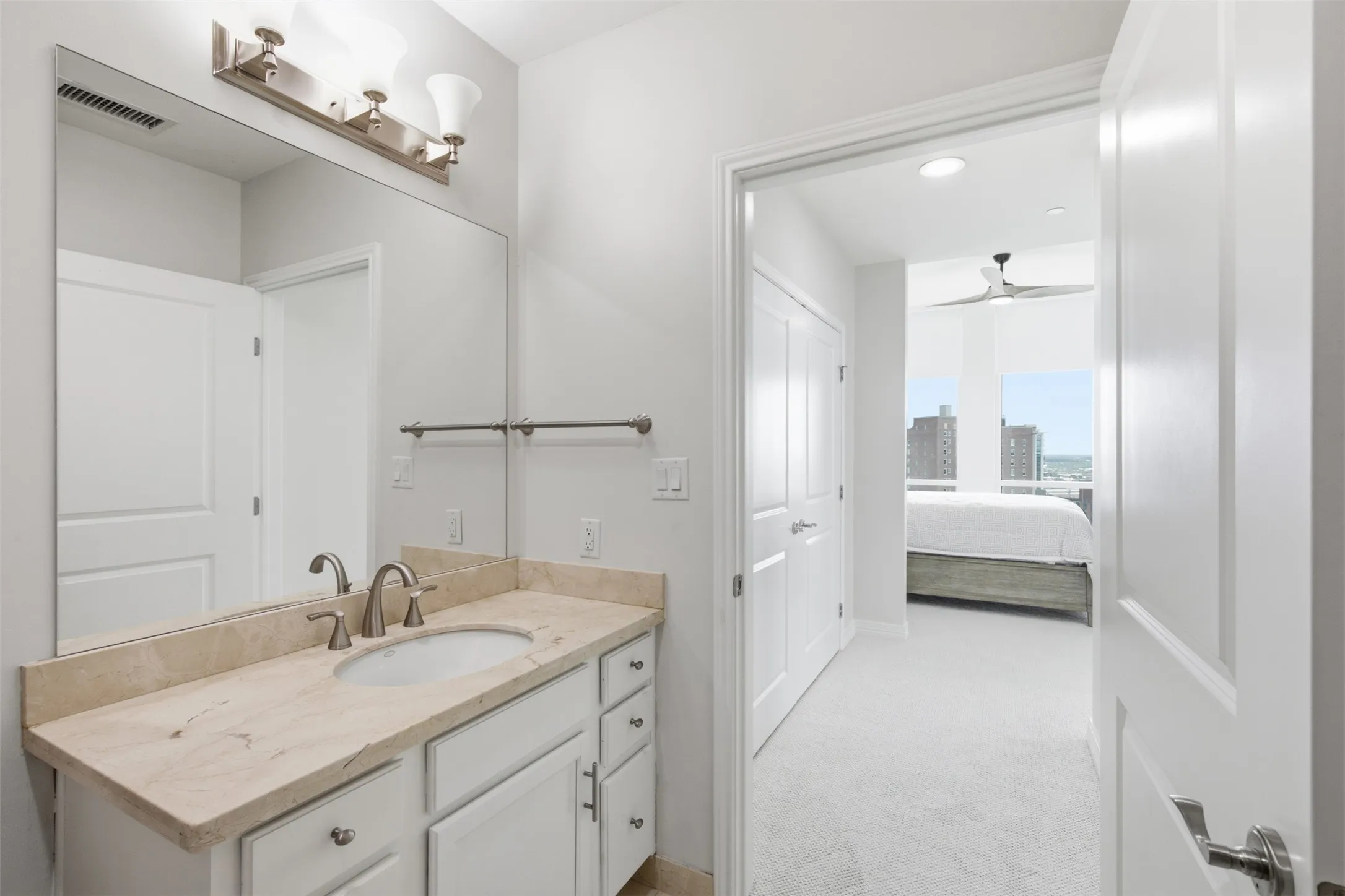 Vanity with stone countertop, undermount sink, and brushed nickel fixtures