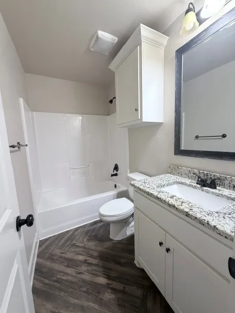 Bathroom featuring a white vanity with a granite-style countertop, undermount sink, and black fixtures