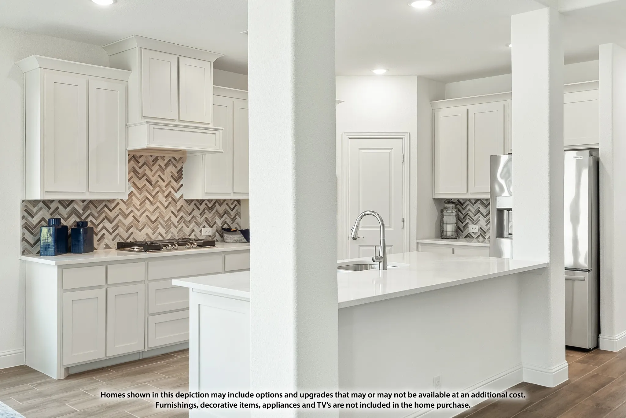 Kitchen featuring white cabinetry, chevron pattern tile backsplash, white countertops, and stainless steel appliances