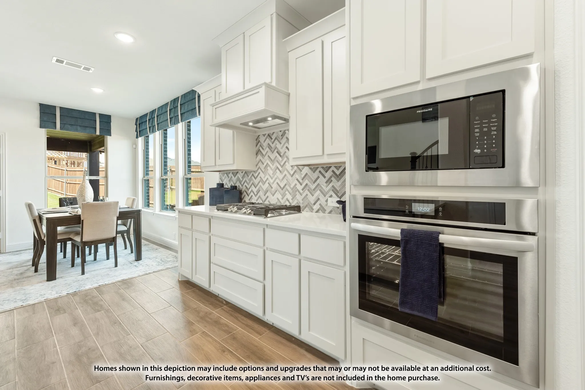 White shaker cabinetry, wood-finish flooring, stainless steel built-in microwave, stainless steel built-in oven, and a tiled backsplash