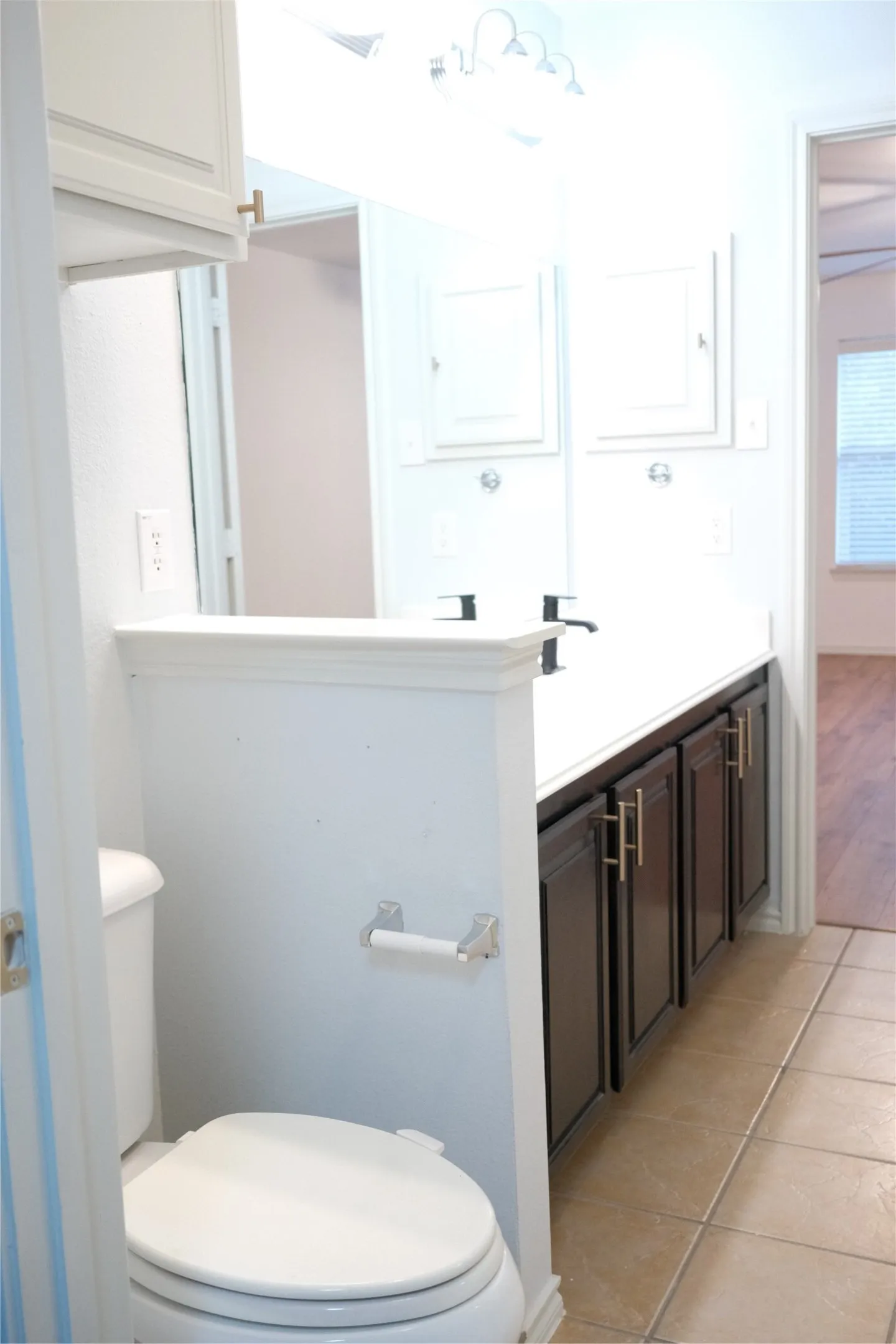 Dual vanity with dark wood-finish cabinetry, white countertop, and integrated sinks