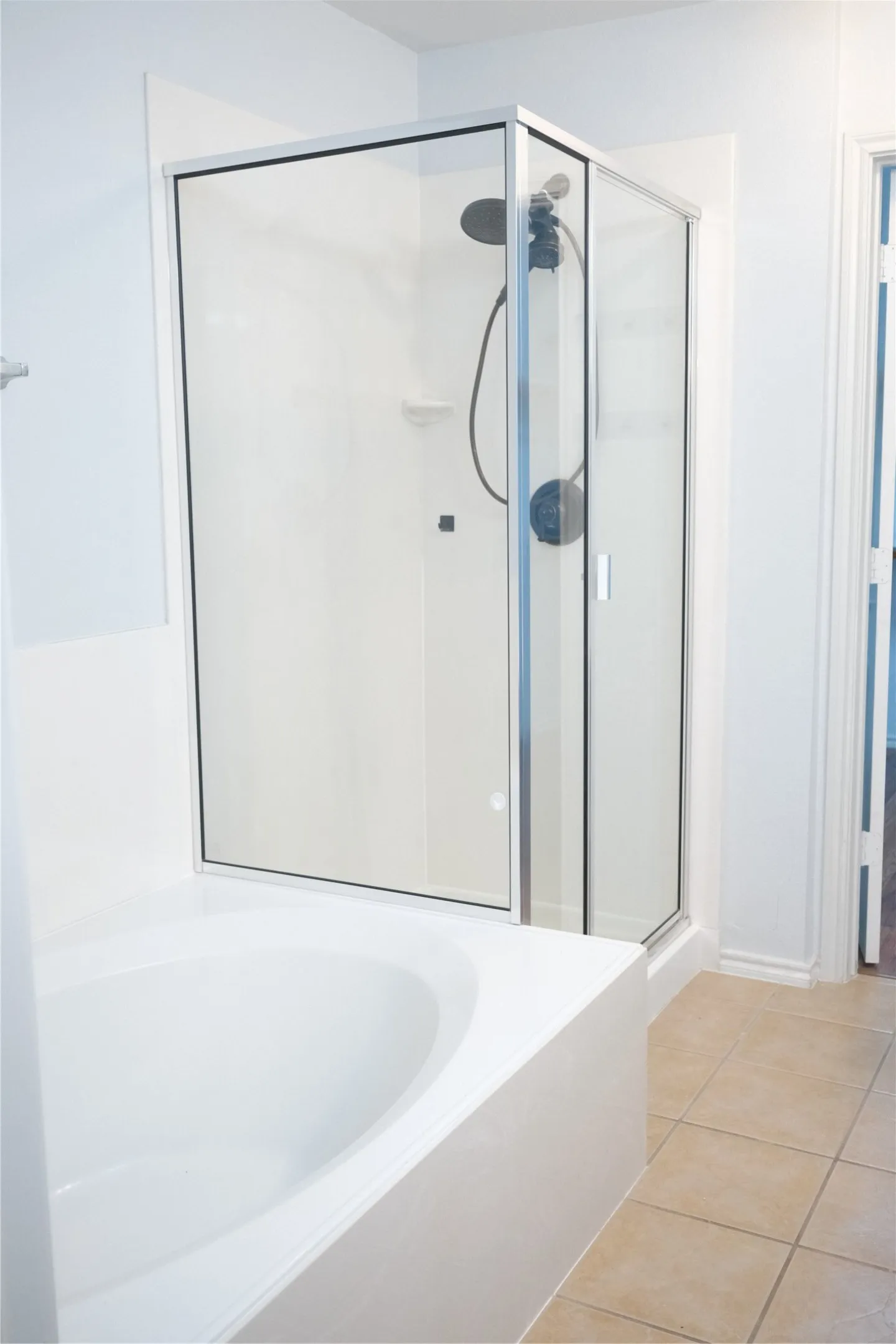 Glass-enclosed shower with matte black fixtures, separate soaking tub, and tile flooring