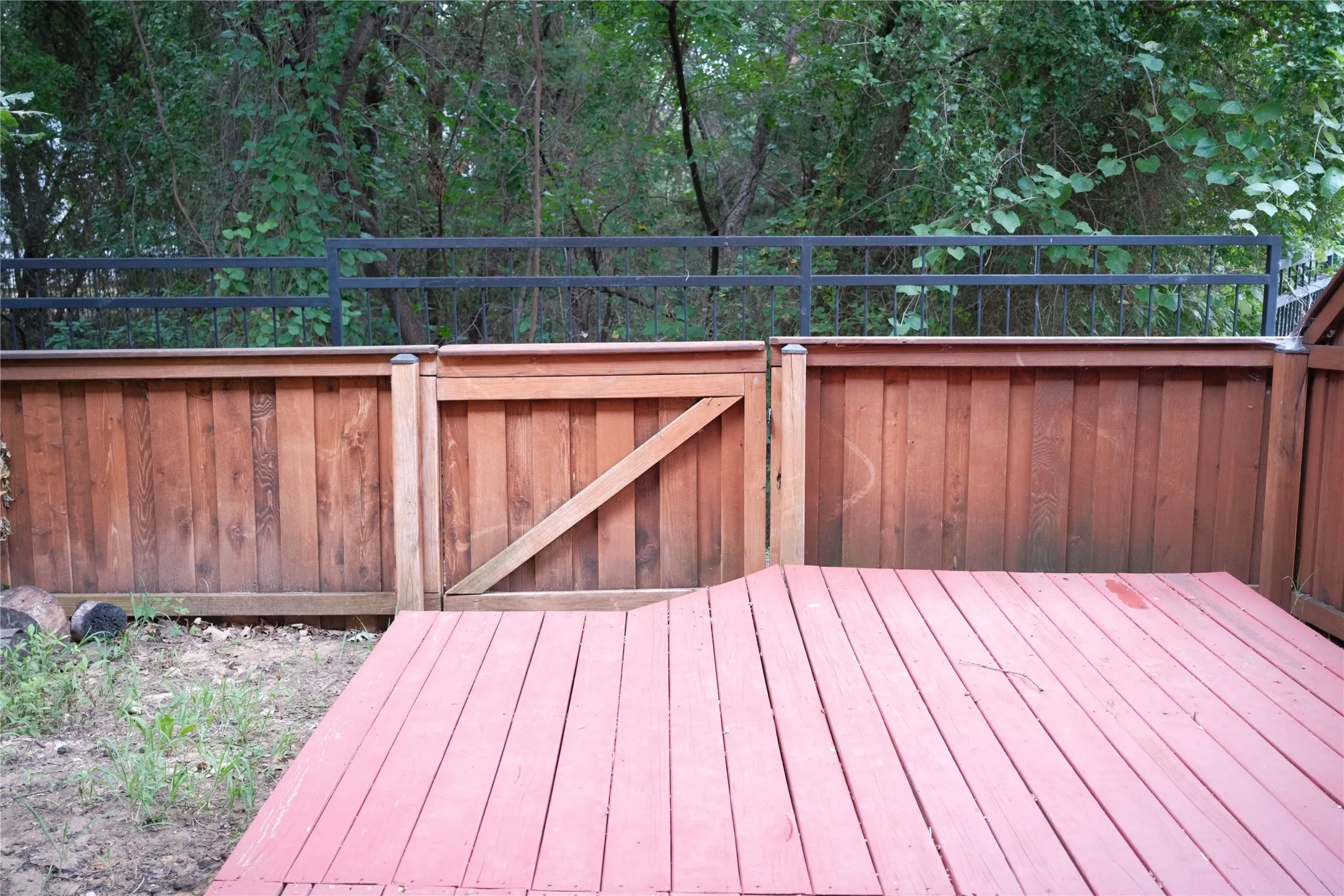 Wood-plank decking, wood privacy fencing, and black metal perimeter railing