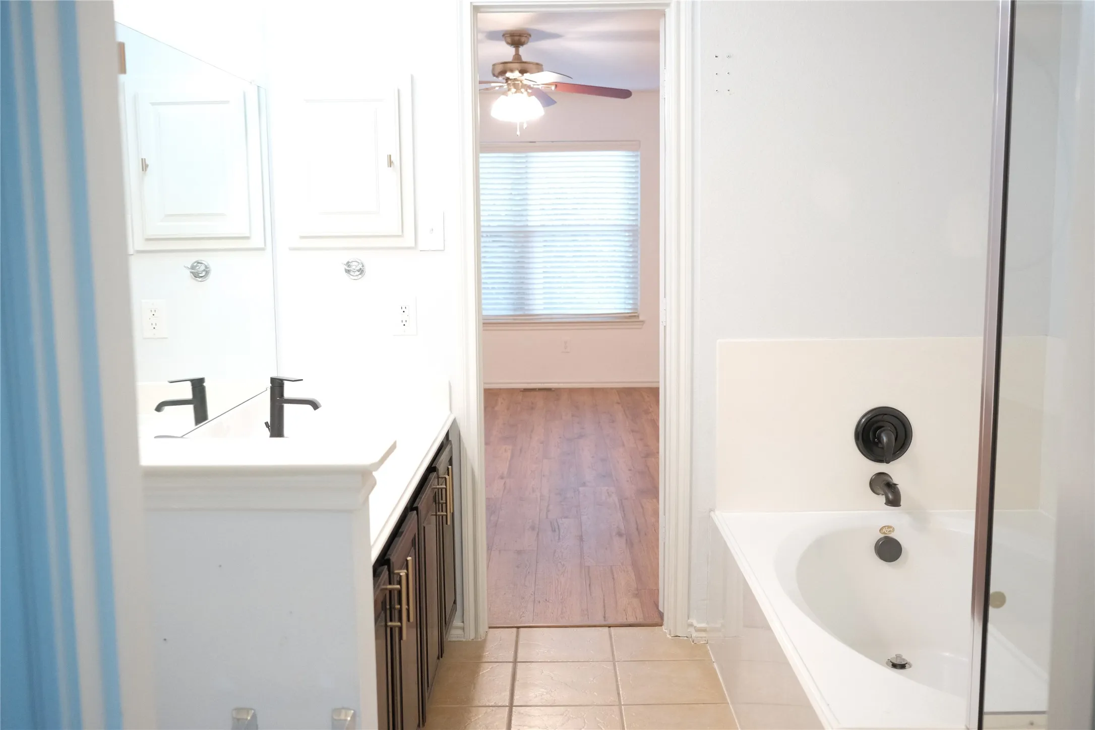 Dual vanity with undermount sinks, dark wood-finish cabinetry, and matte black faucets