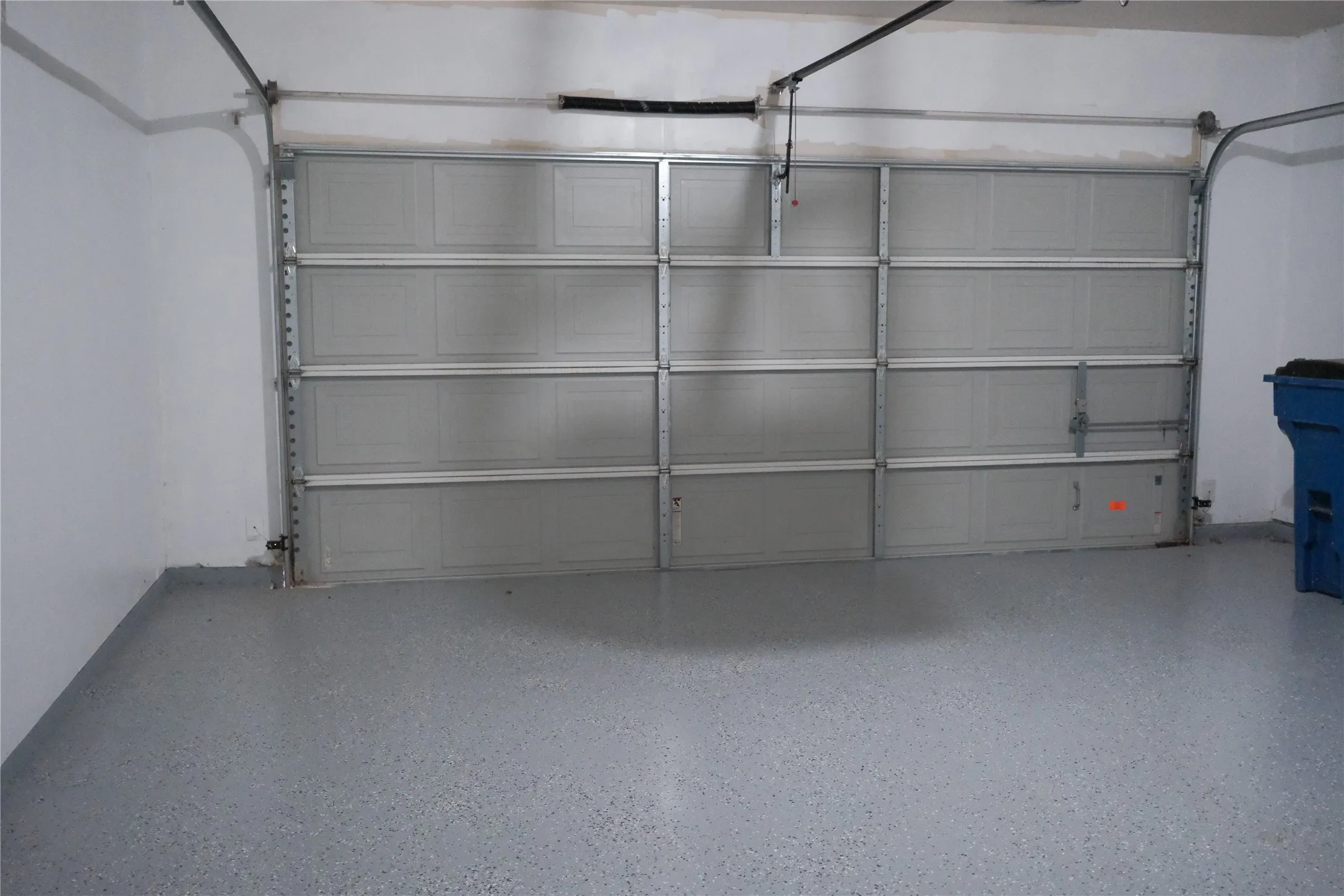 Three-car garage with an epoxy-coated floor and paneled garage doors