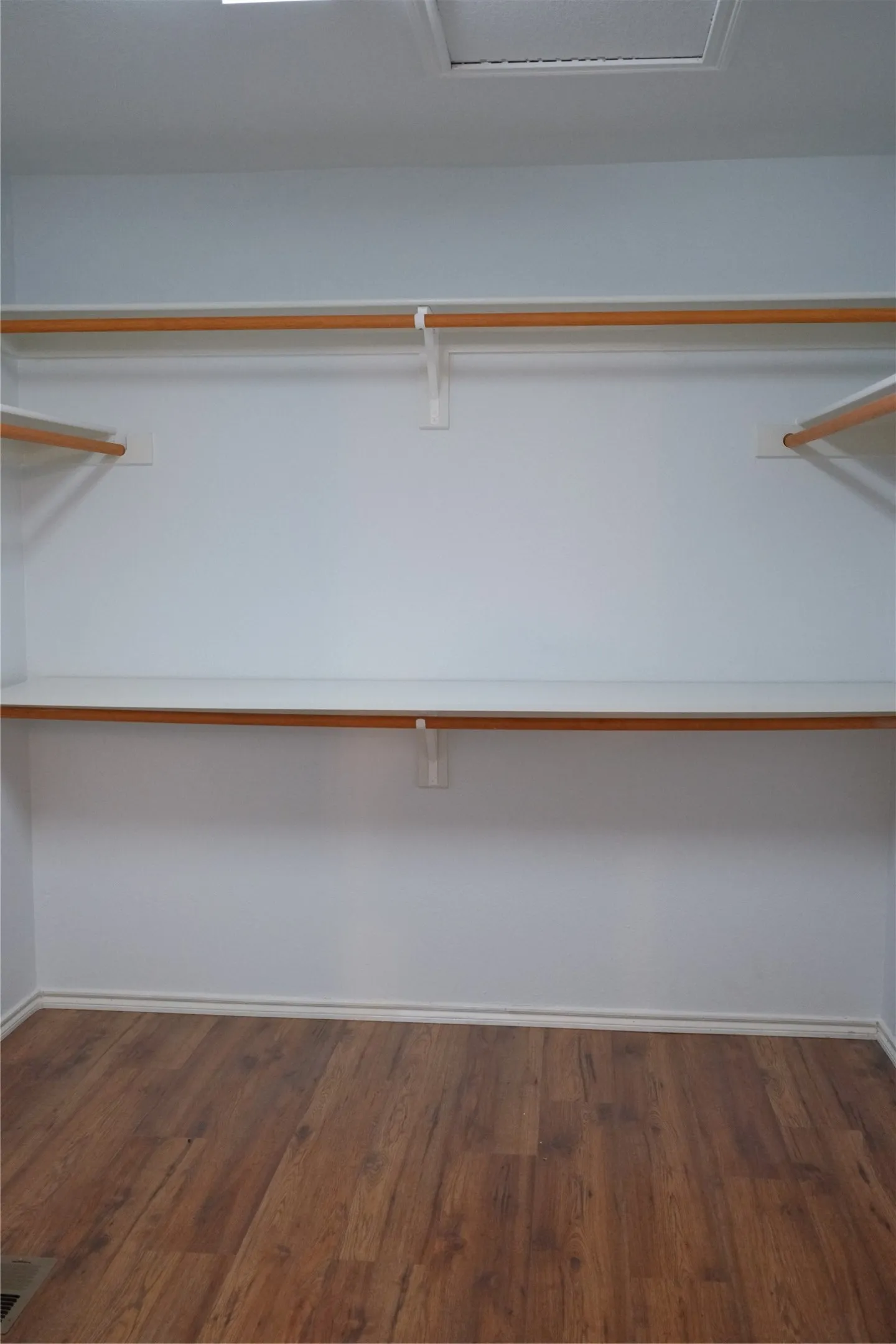 Wood-finish flooring with built-in shelving and clothing rods