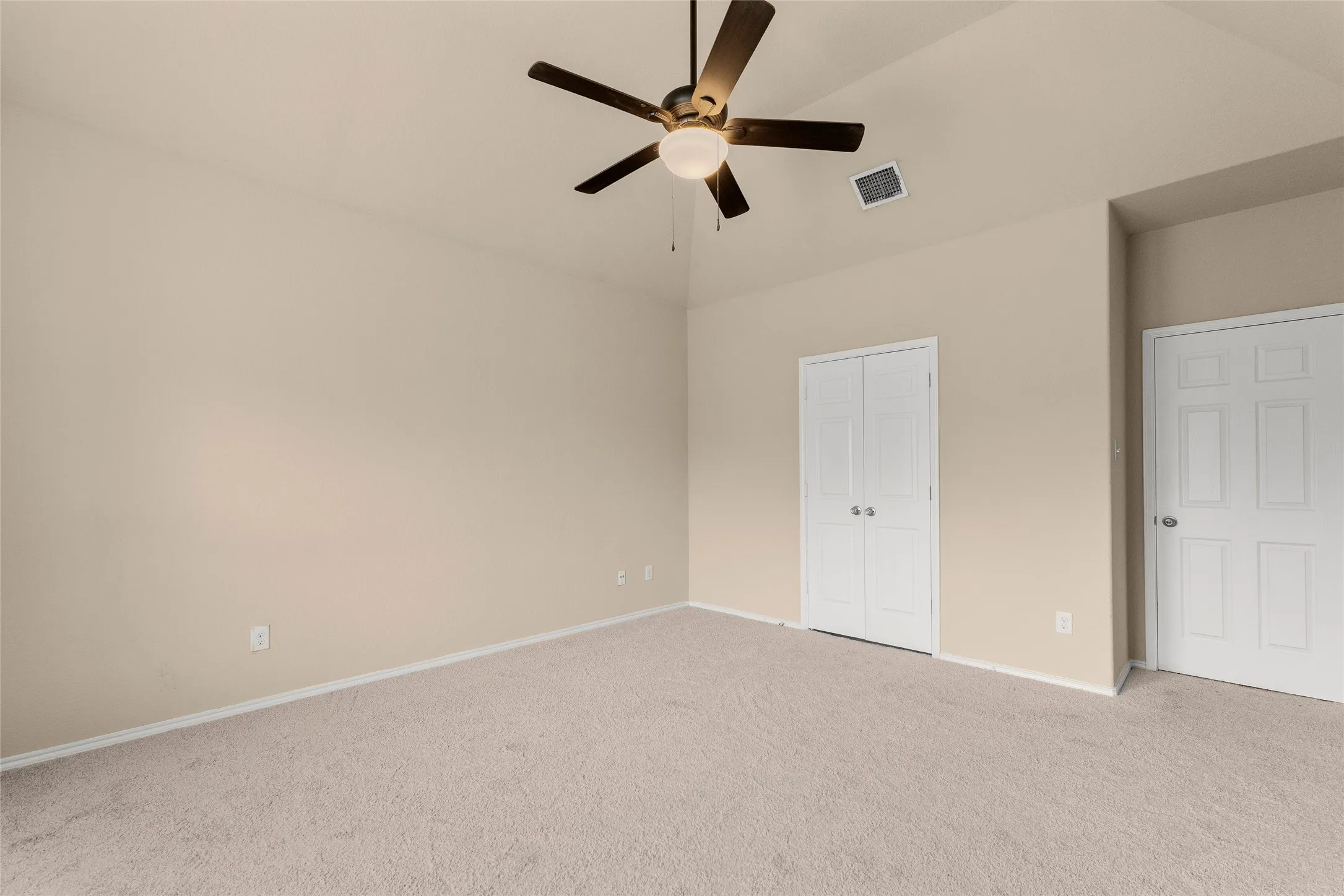 Unfurnished bedroom featuring carpet flooring, a closet, ceiling fan, and vaulted ceiling