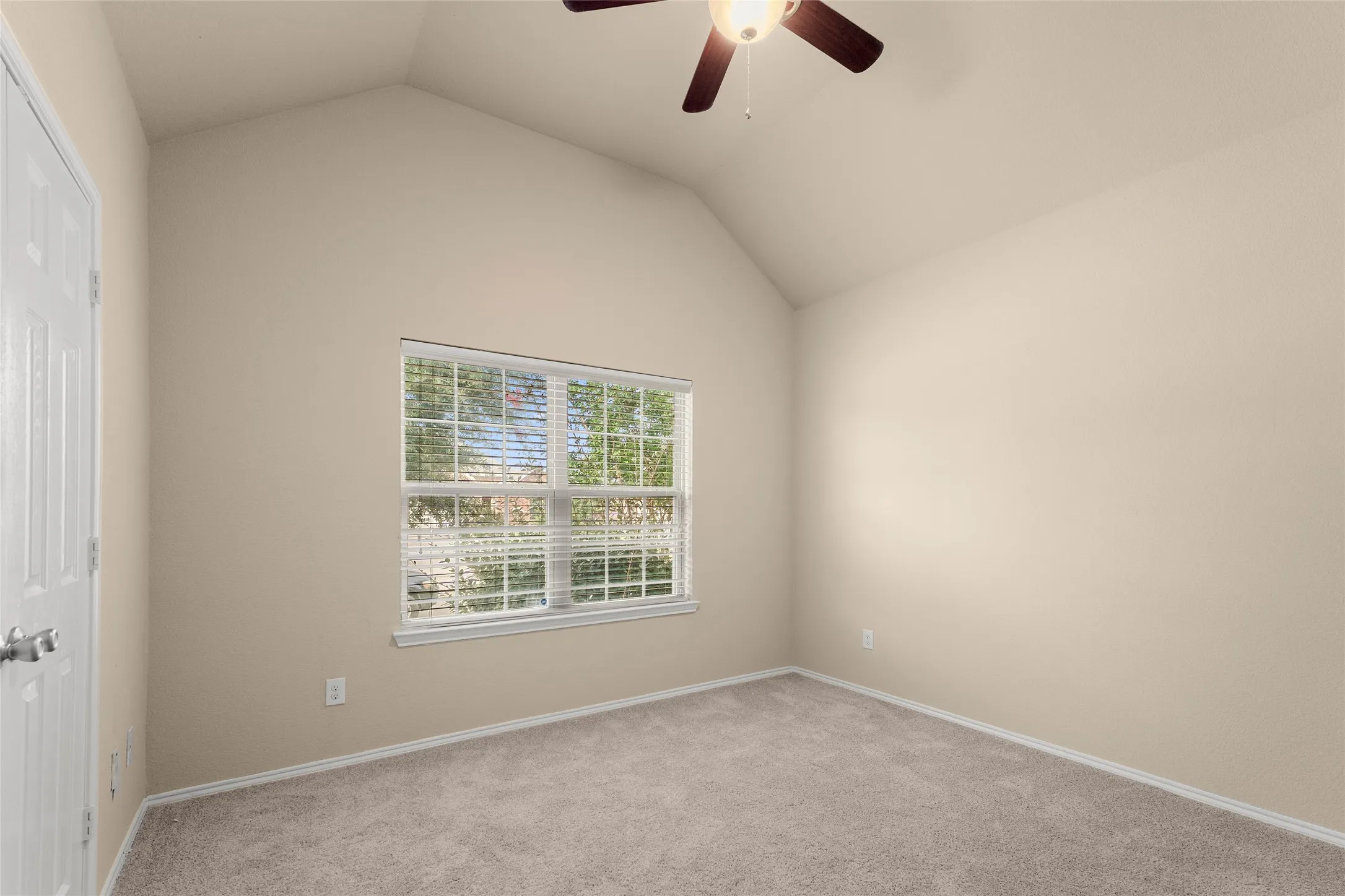 Empty room with light carpet, lofted ceiling, and ceiling fan