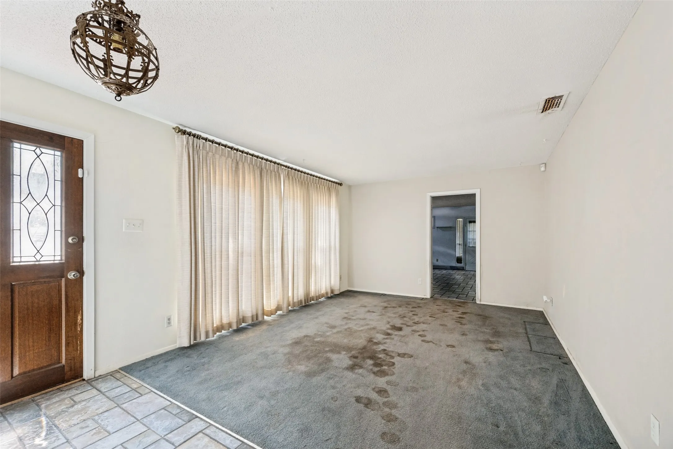 Entryway featuring a decorative glass panel door and tiled flooring
