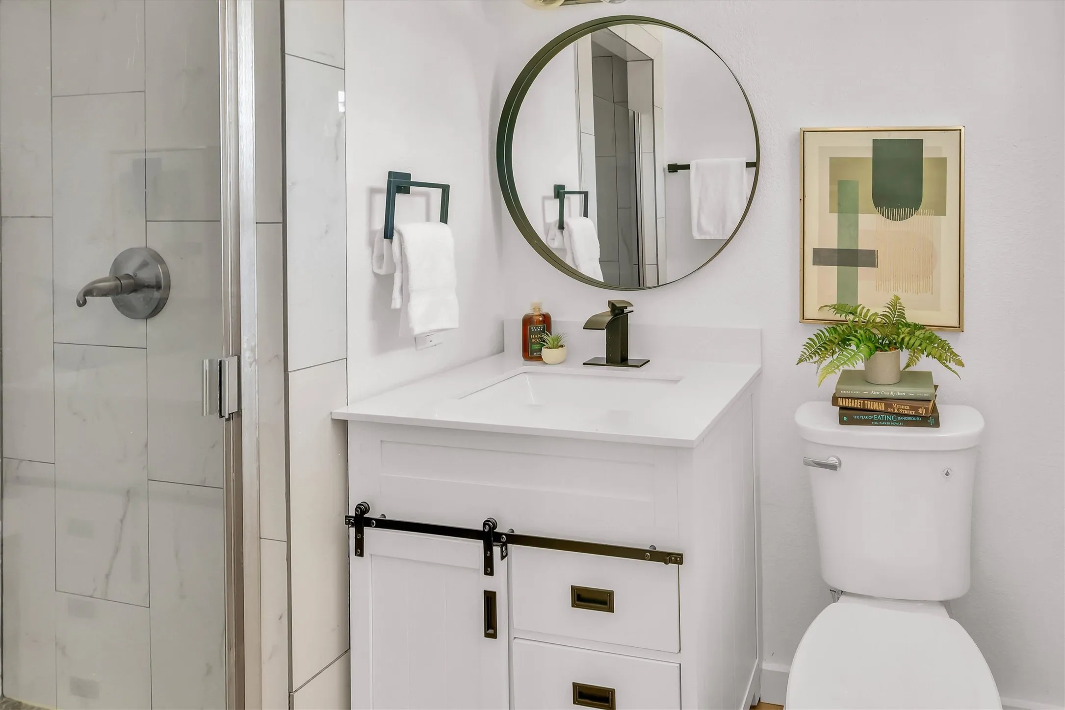 White vanity with a solid surface countertop, undermount sink, and matte black faucet