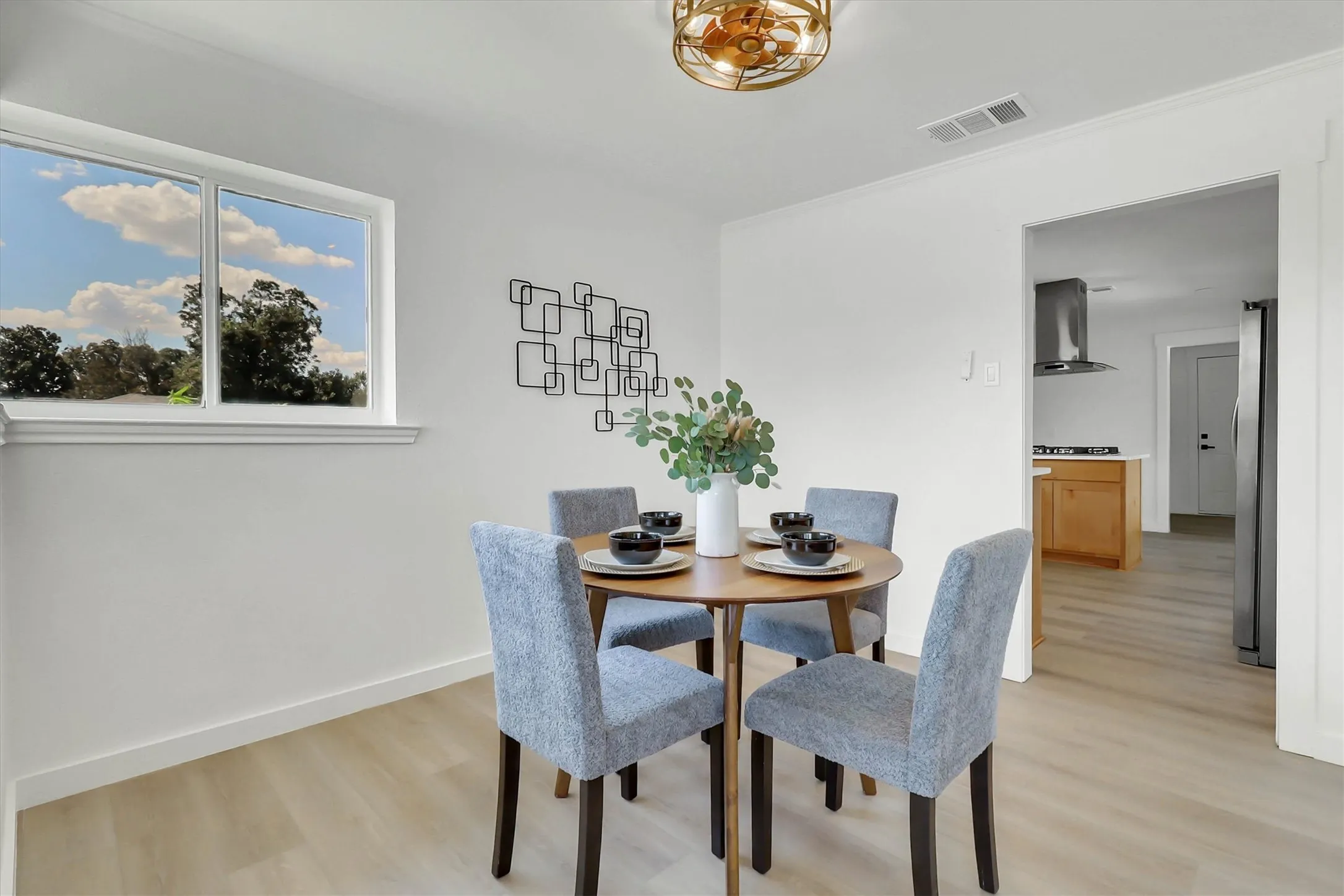 Light wood-finish flooring, white walls, and a contemporary ceiling light fixture