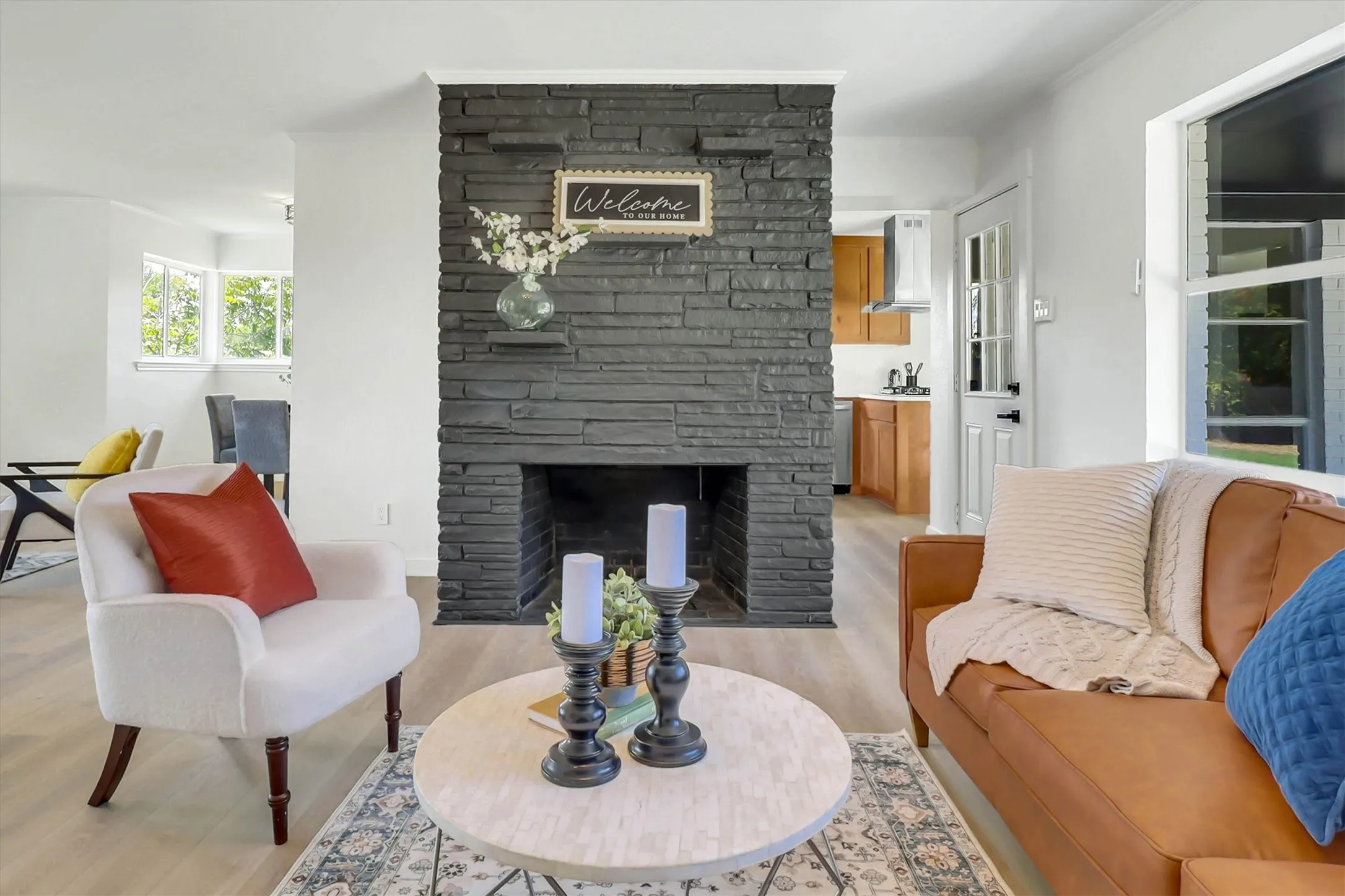 Floor-to-ceiling black stacked stone fireplace with a wood mantel