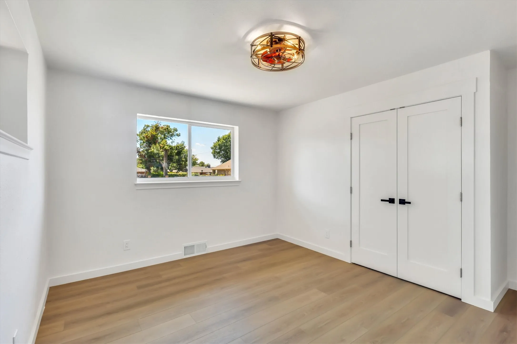 Wood-finish flooring, white walls, and a contemporary ceiling light fixture